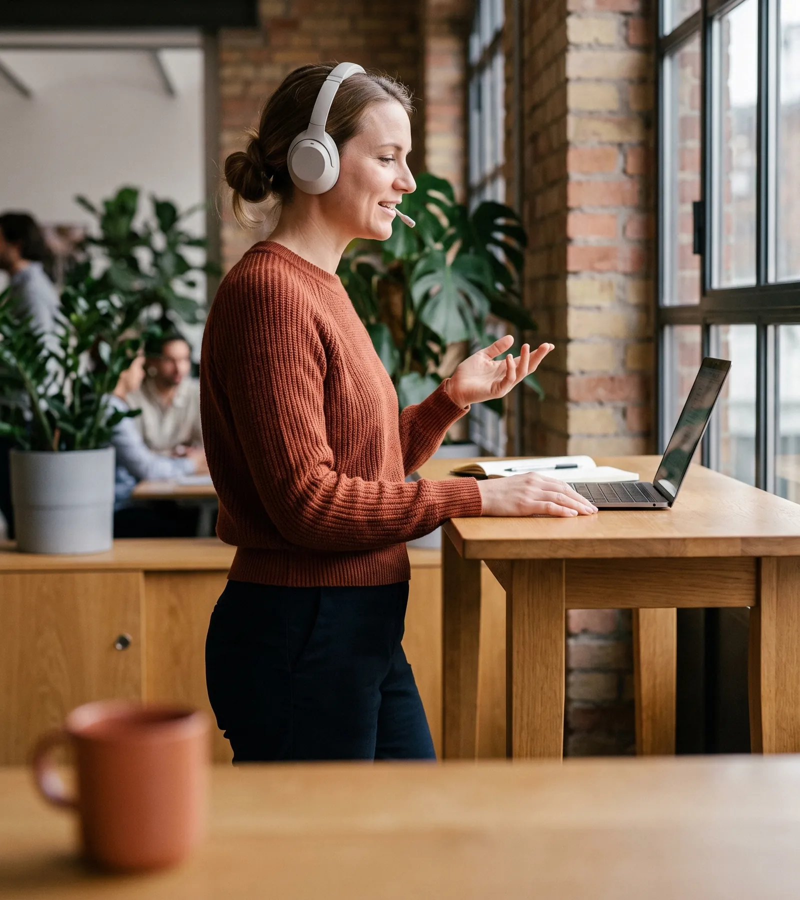Sales manager with a headset on a call with a prospect at a standing desk