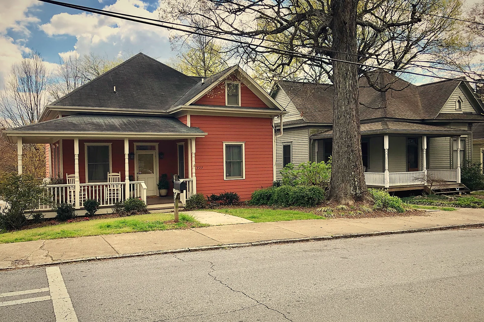 A red shotgun-style house beside a gray cottage on Kirkwood Avenue in Cabbagetown