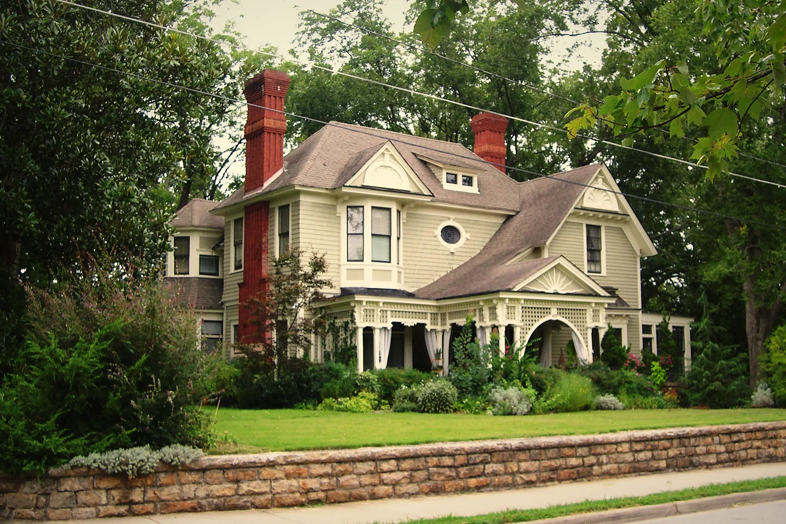 A Victorian house behind a stone wall on Sycamore Street in Decatur