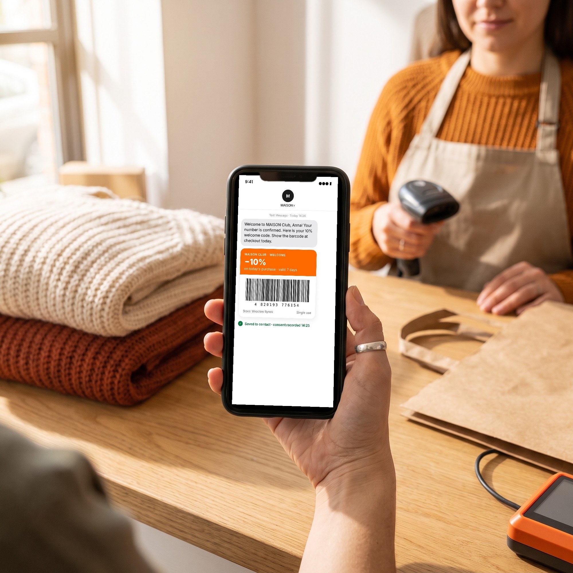 Shopper's phone showing an SMS welcome code with a barcode, ready to scan at checkout