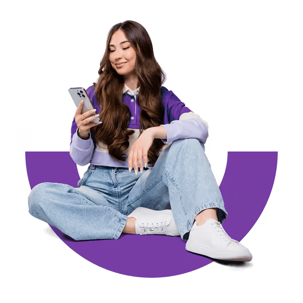 Smiling woman sitting cross-legged looking at her phone