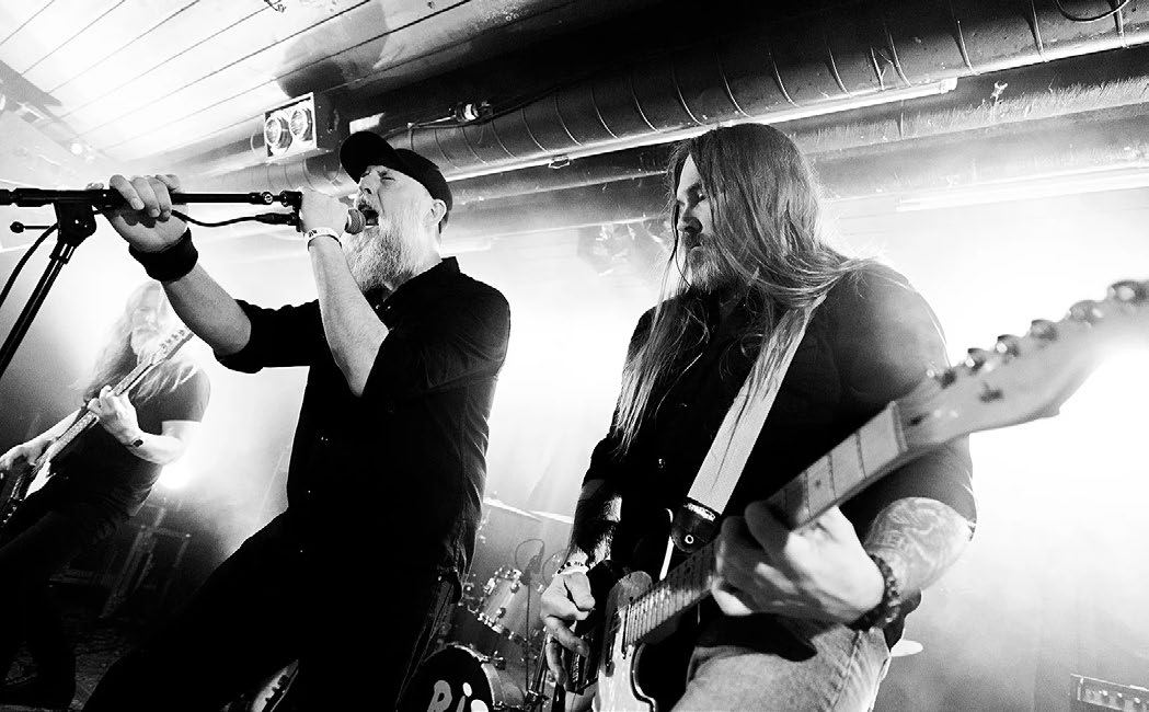 Singer and guitarist on stage in white backlight