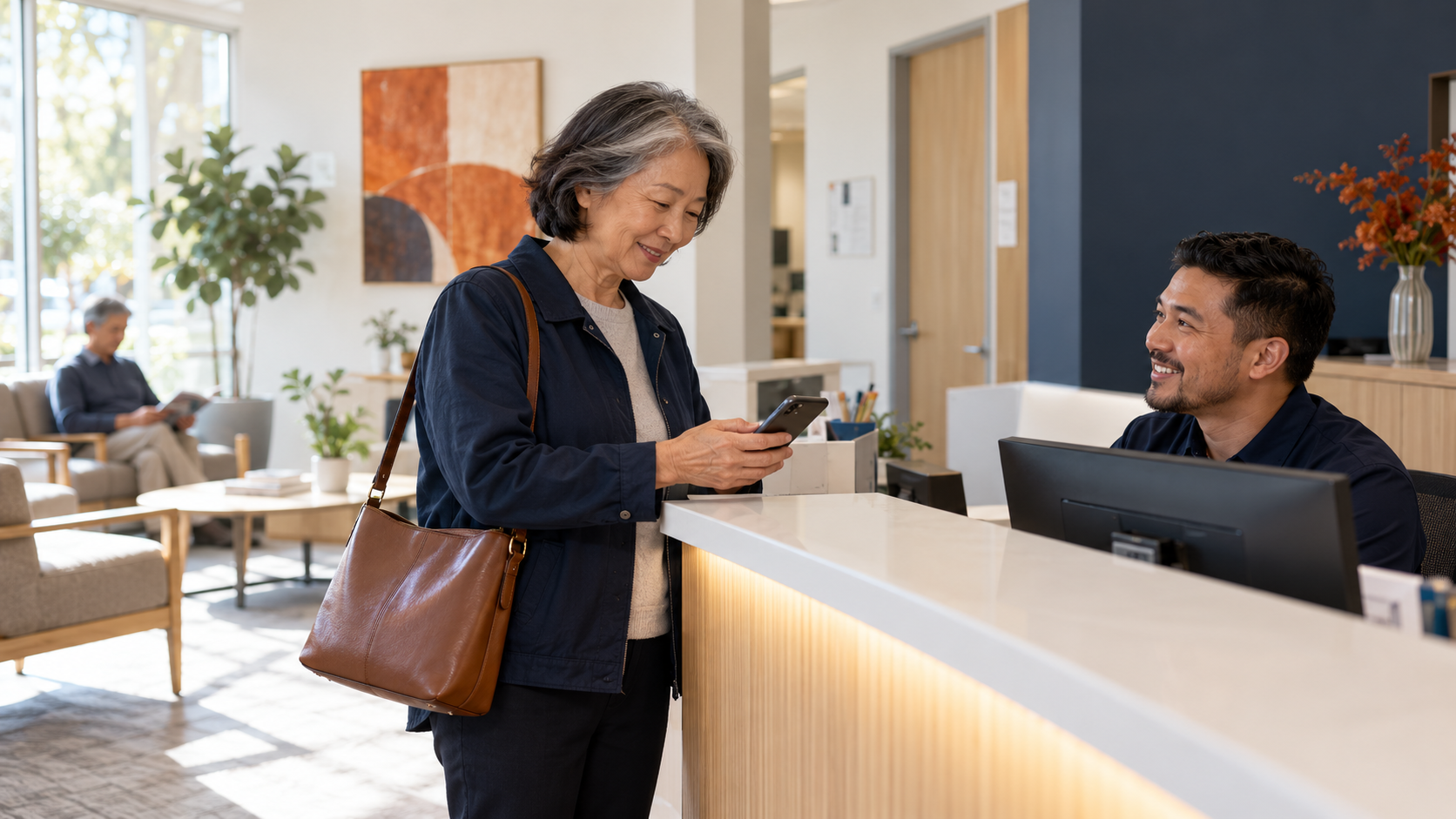 Patient showing her insurance details on her phone at reception