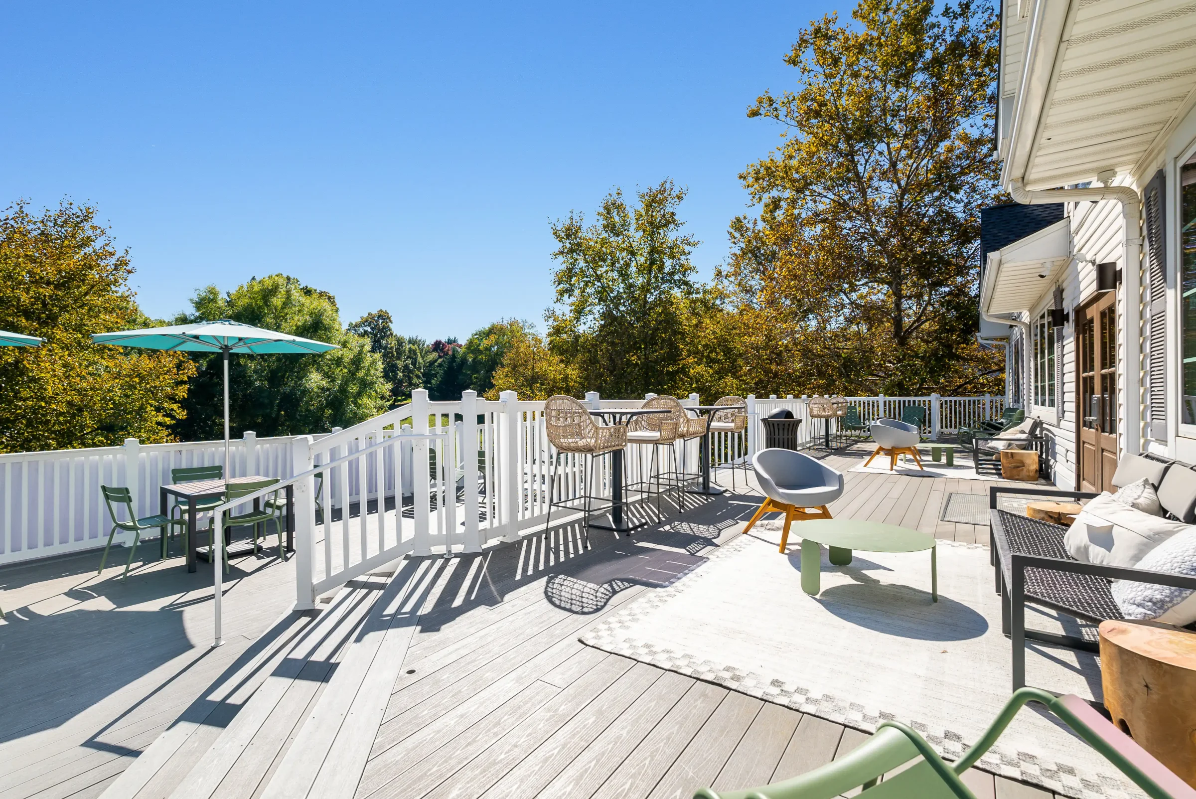 Clubhouse deck with umbrellas and trees at The Hills Southview