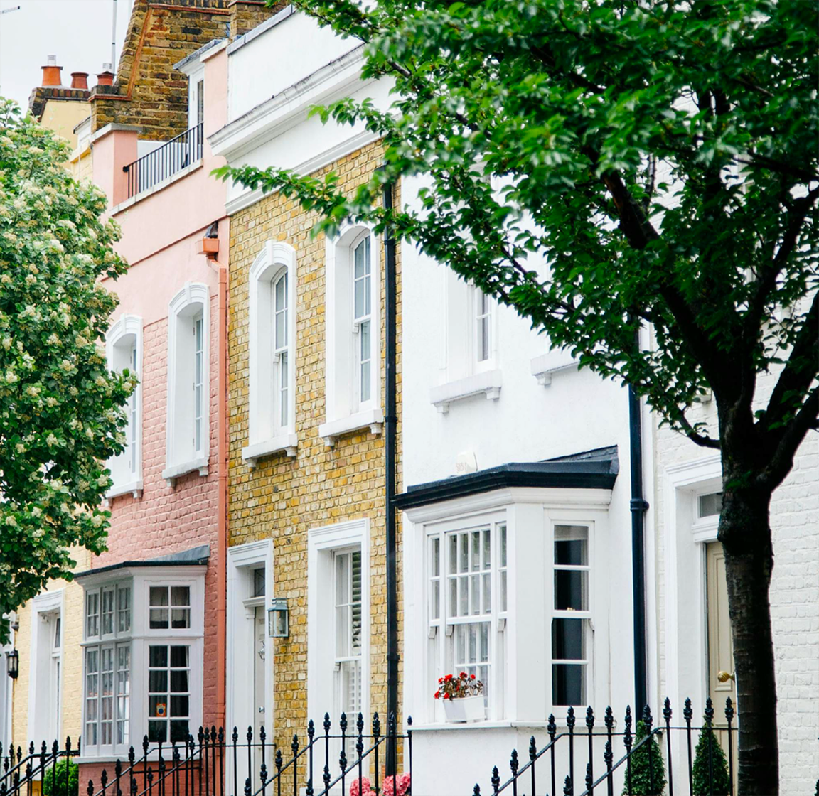 Pastel terraced houses on a tree-lined London street