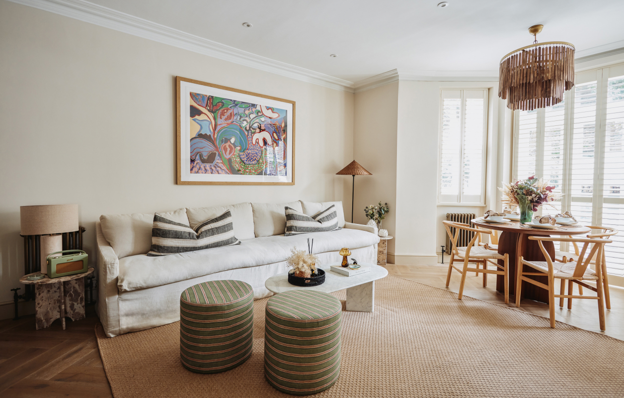 Light sitting room with sofa, artwork and dining area
