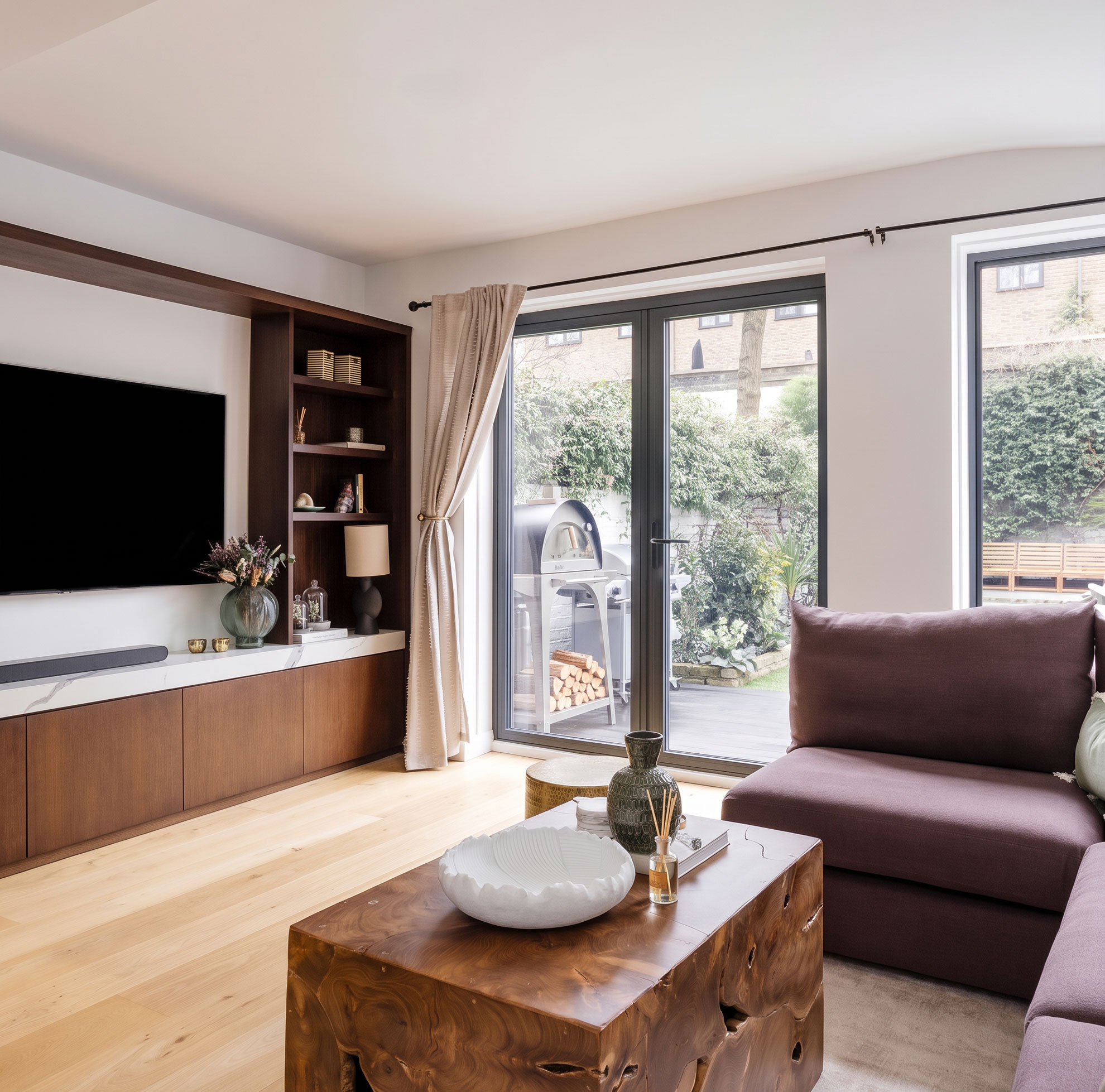 Living room with built-in shelving and garden doors in a managed short-let property