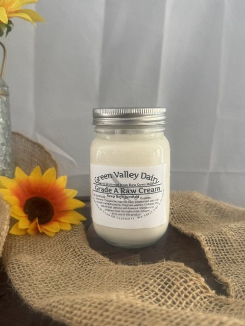 Pint jar of Green Valley Dairy Grade A raw cream, hand skimmed from raw cow milk, on burlap with a sunflower