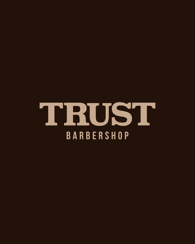 TRUST Barbershop wordmark in sand on espresso