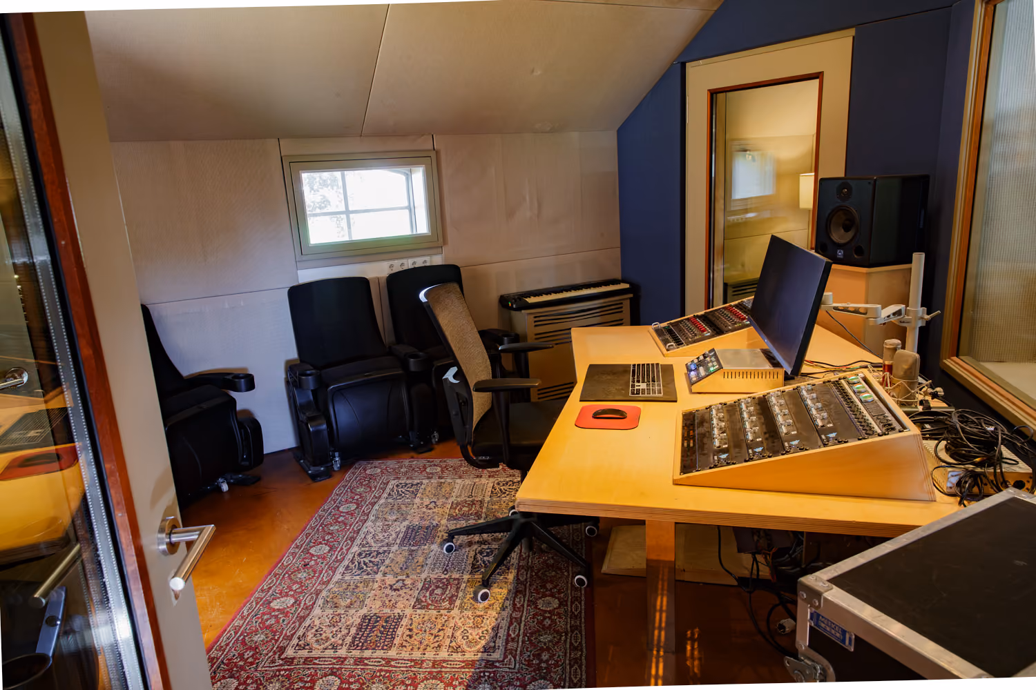 Studio 1 control room with a plywood desk, angled API preamp rack, monitor, studio speaker and cinema seats