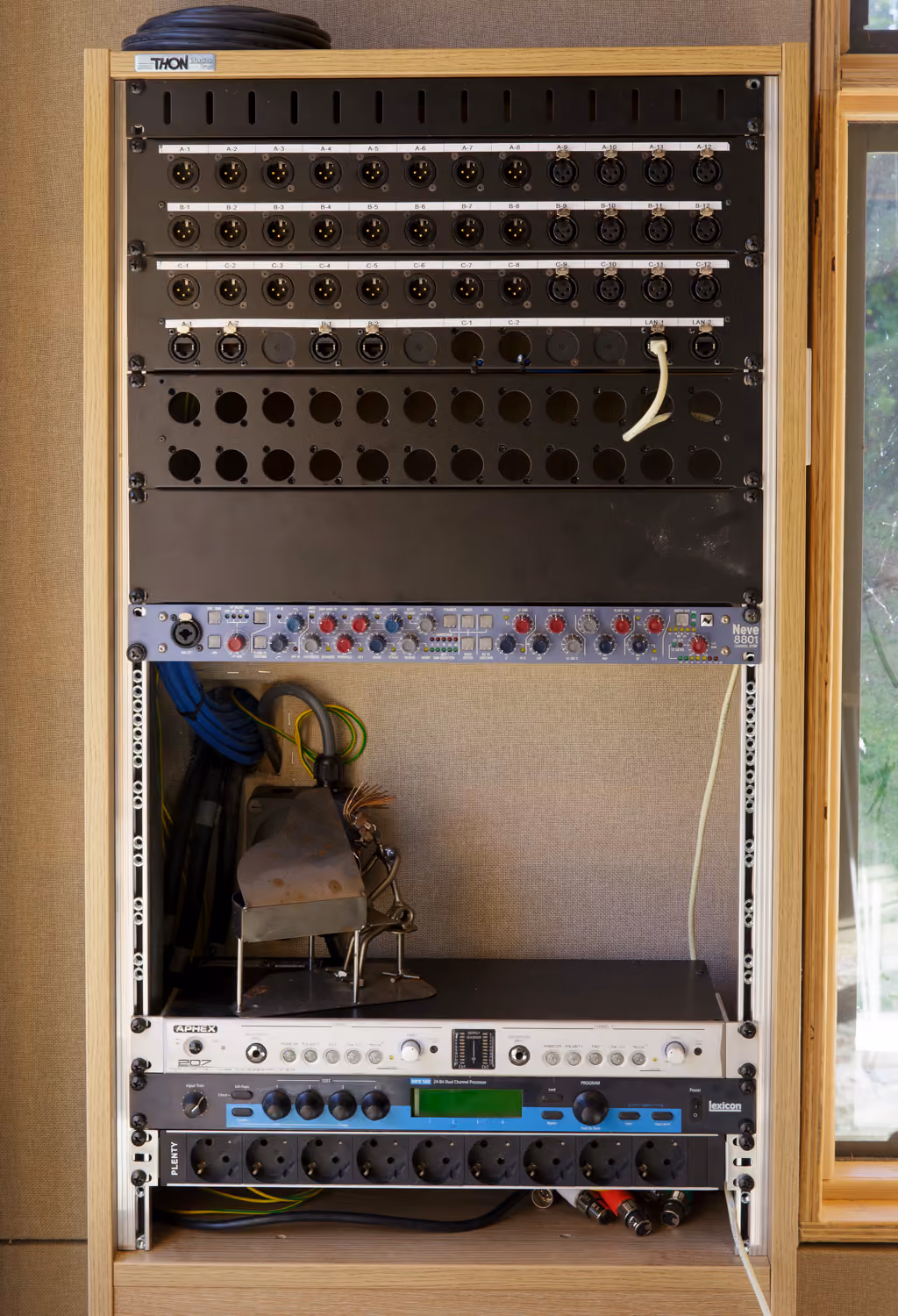Studio rack with XLR patch panels, a Neve 8801 channel strip, an Aphex 207 preamp and a Lexicon effects unit