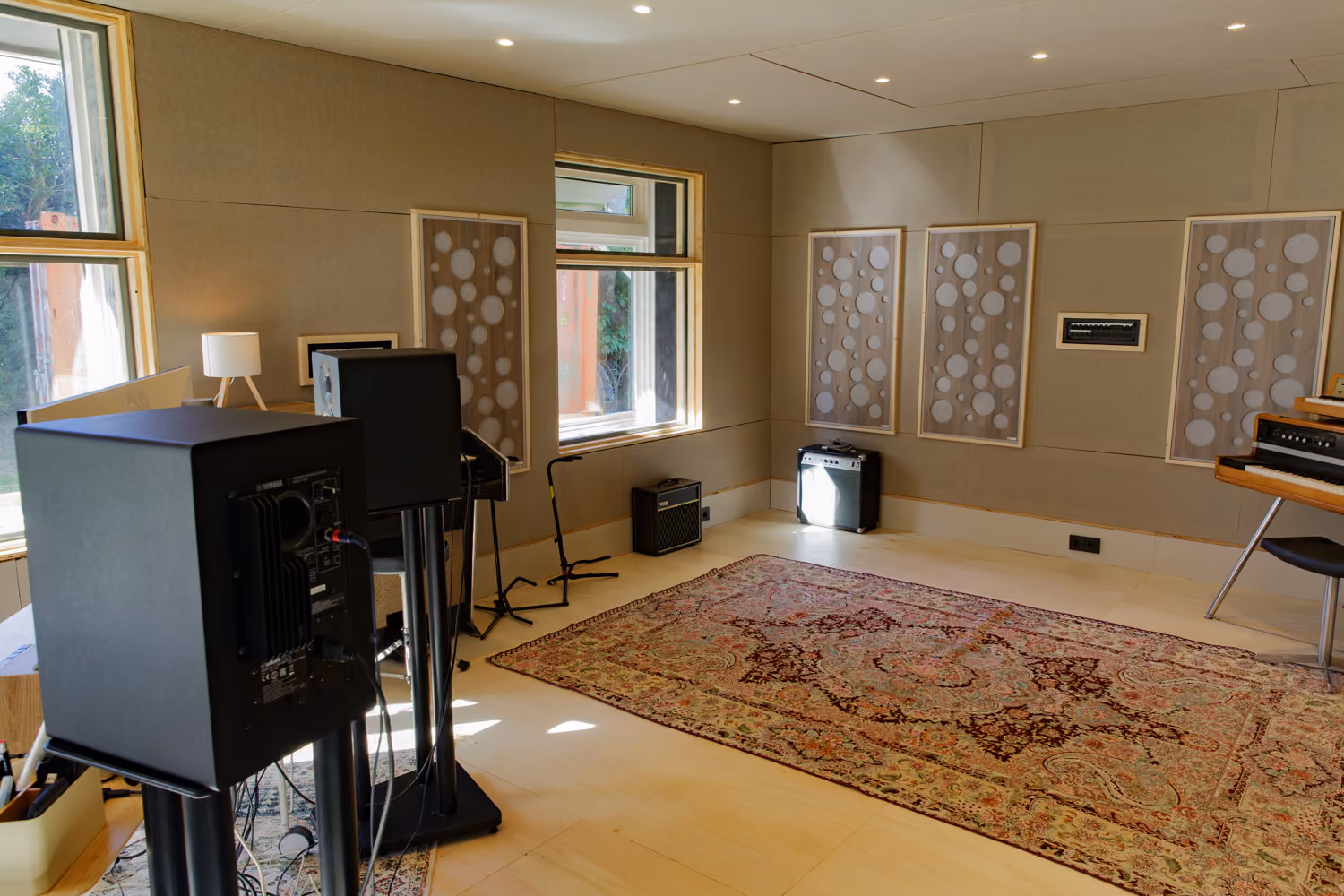 Studio 2 production room with a Persian rug, Yamaha monitors, Vox and combo amps and a vintage electric piano