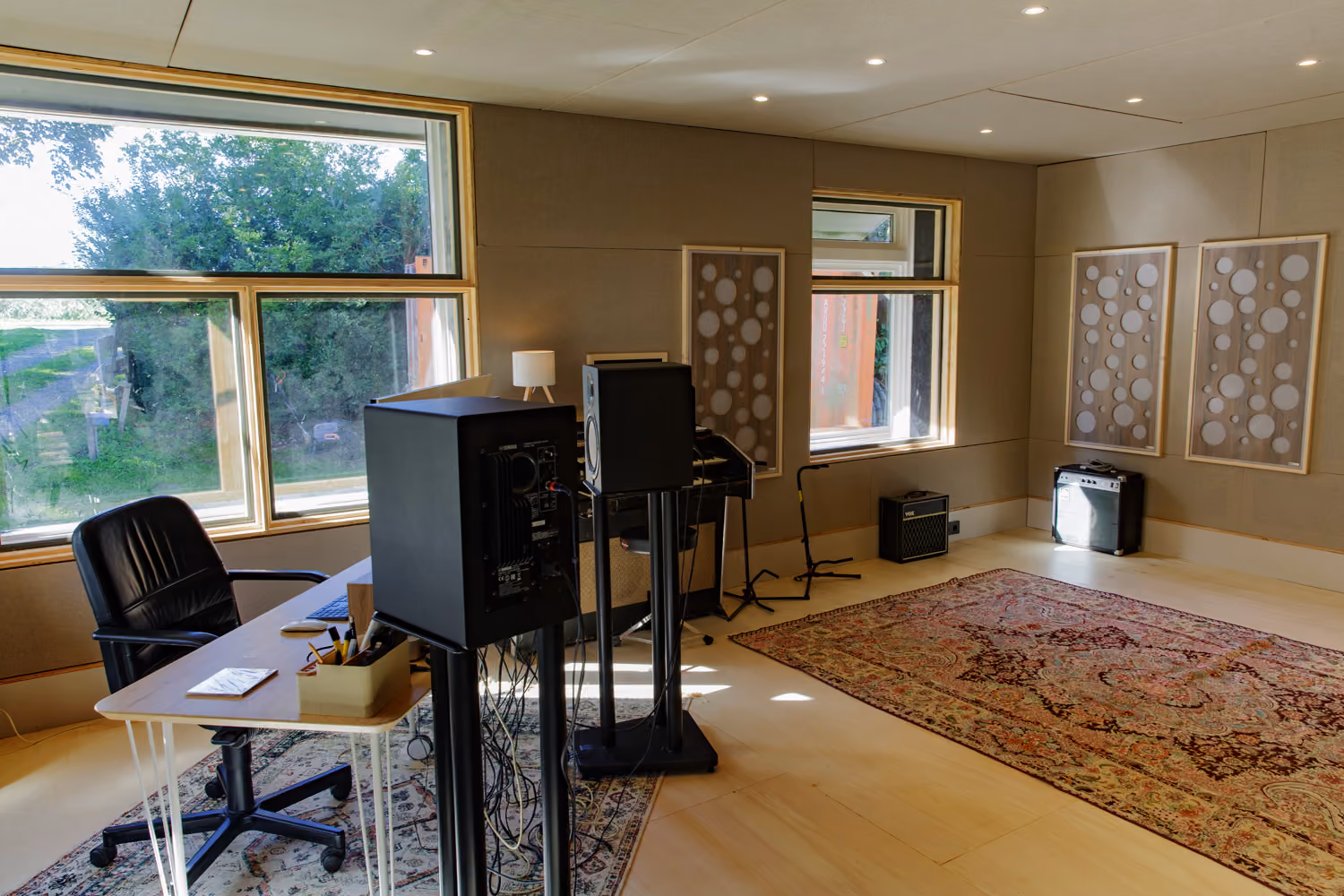 Studio 2 daylight production room with a desk, Yamaha monitors, combo amps and a large Persian rug