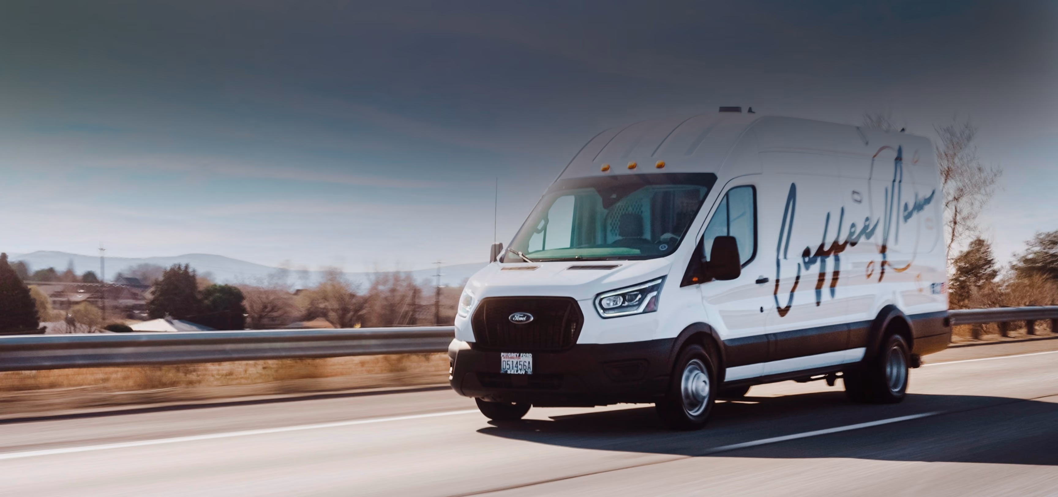 A CoffeeNow van driving down the freeway