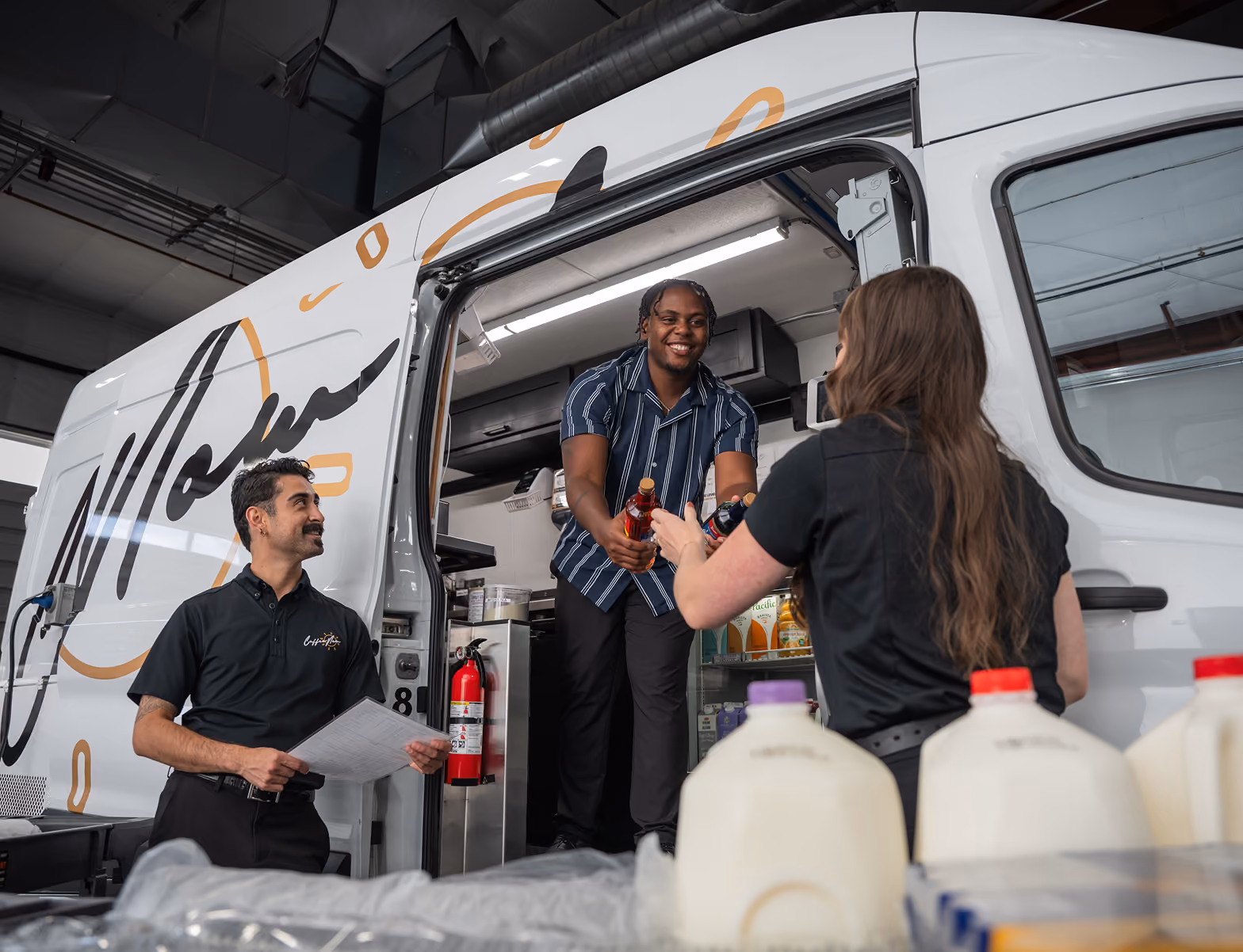 A CoffeeNow franchisee learns how to stock a delivery van.