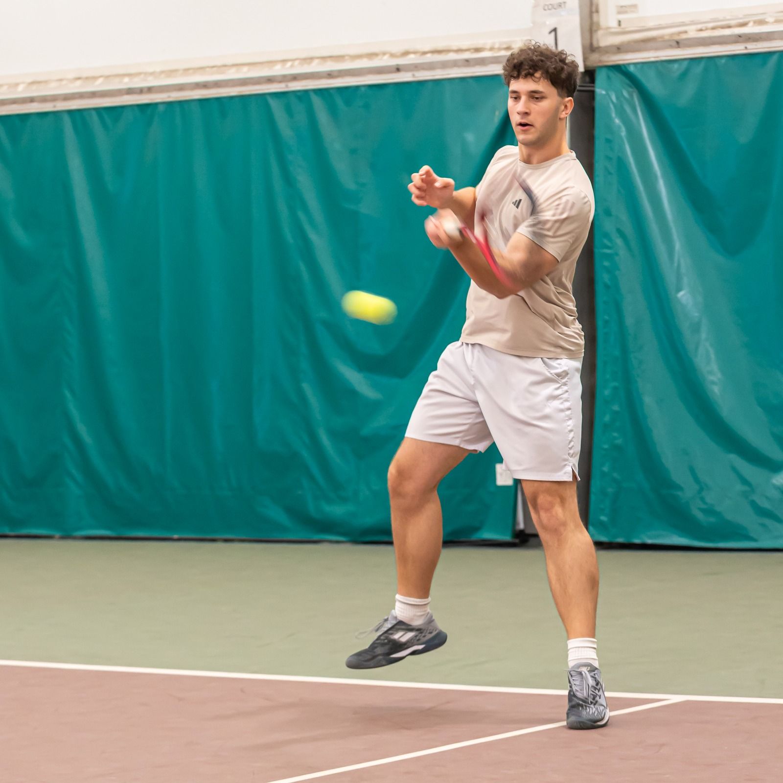 Player hitting a forehand in the indoor hall