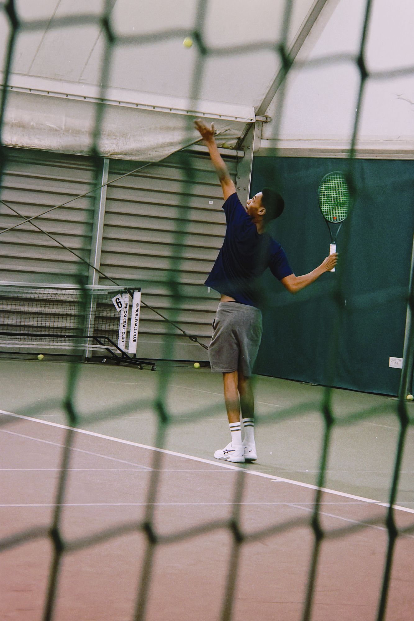 Player tossing up to serve in the indoor hall