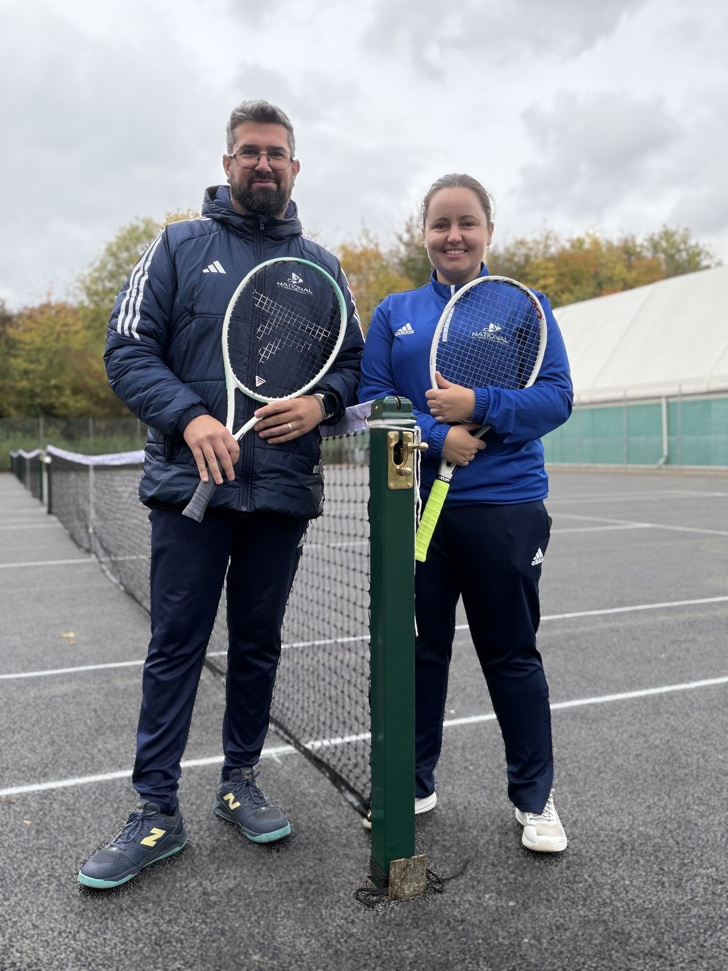 Two club players smiling at the net on the indoor courts at War Memorial Park