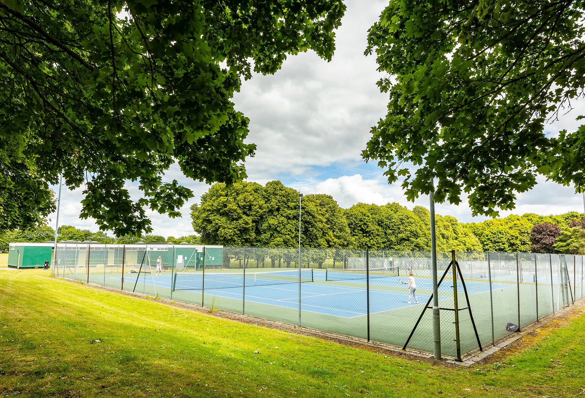 Outdoor tennis courts under the trees at Stratton Park