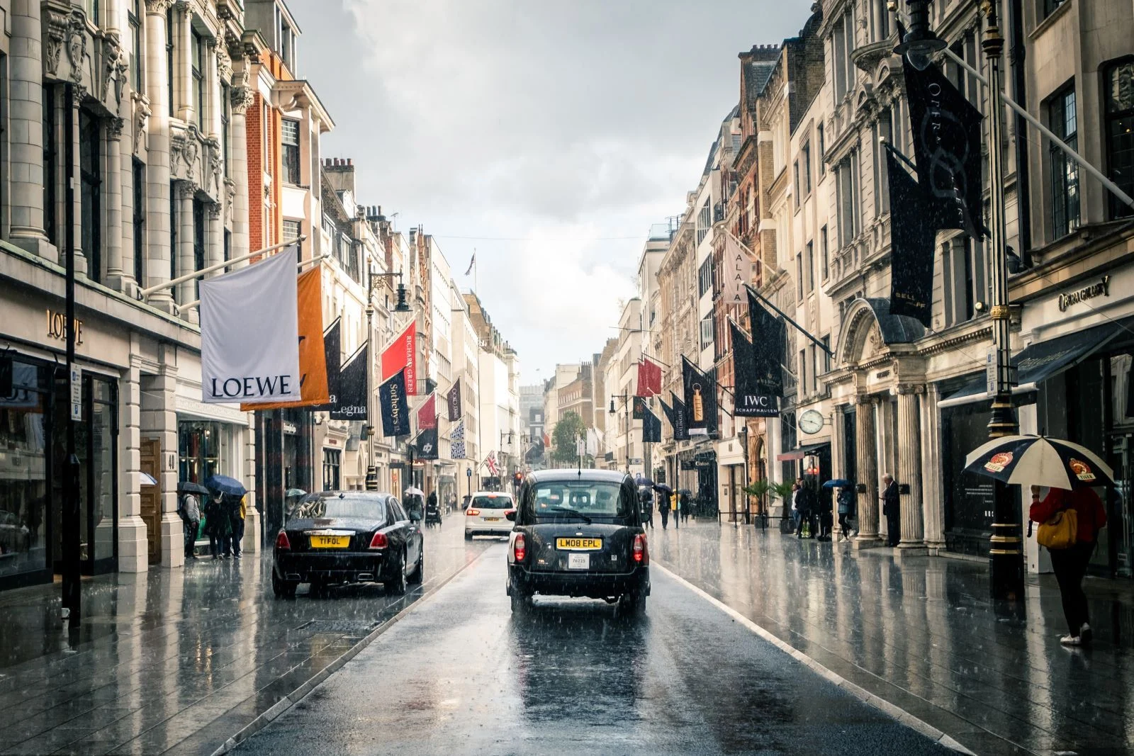 Bond Street, London showing luxury fashion shops and black cab.