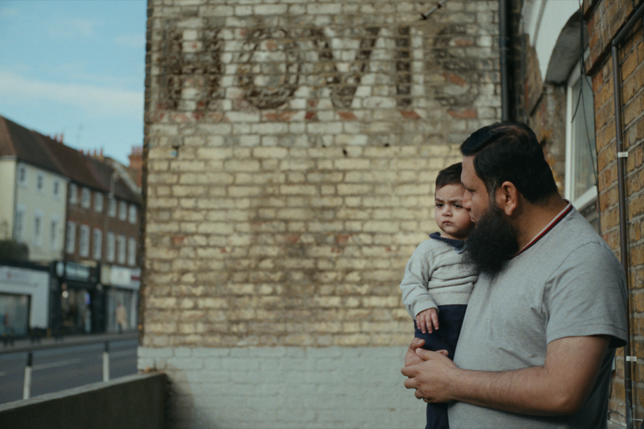 A father and son look out together against a HOVIS ad painted o a northern brick wall. VCCP Strength Baked In