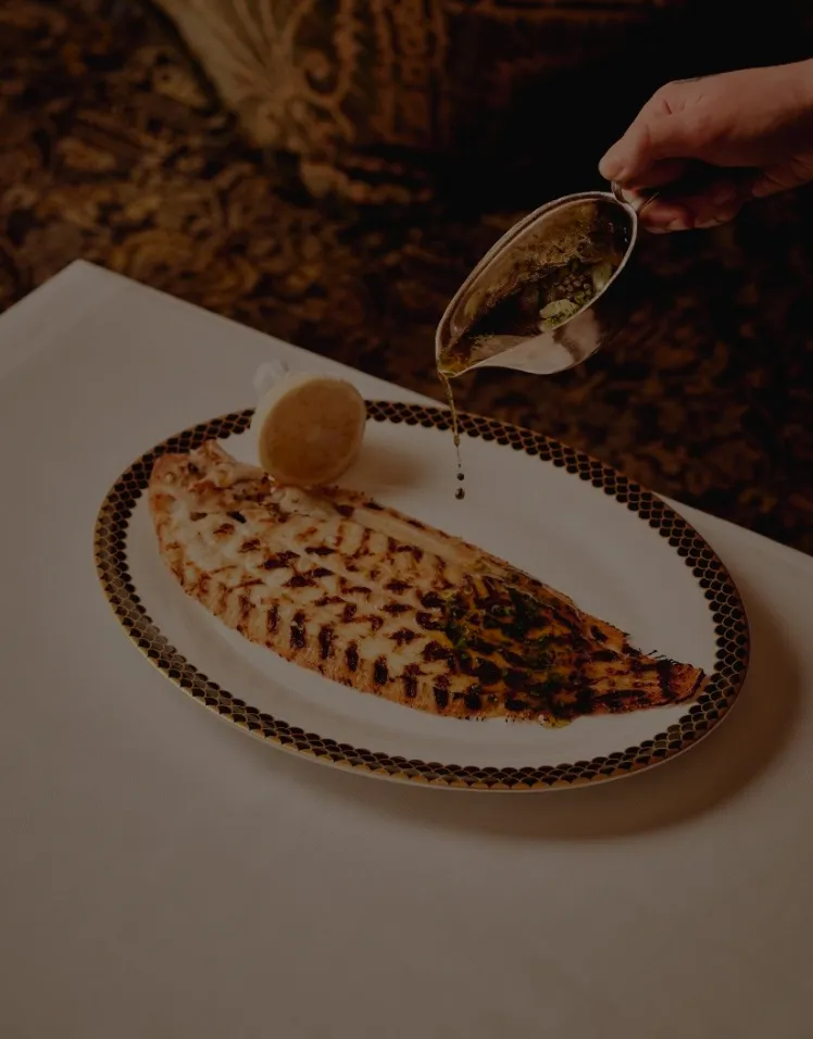 Sole grillée nappée de beurre aux herbes, servie avec un demi-citron