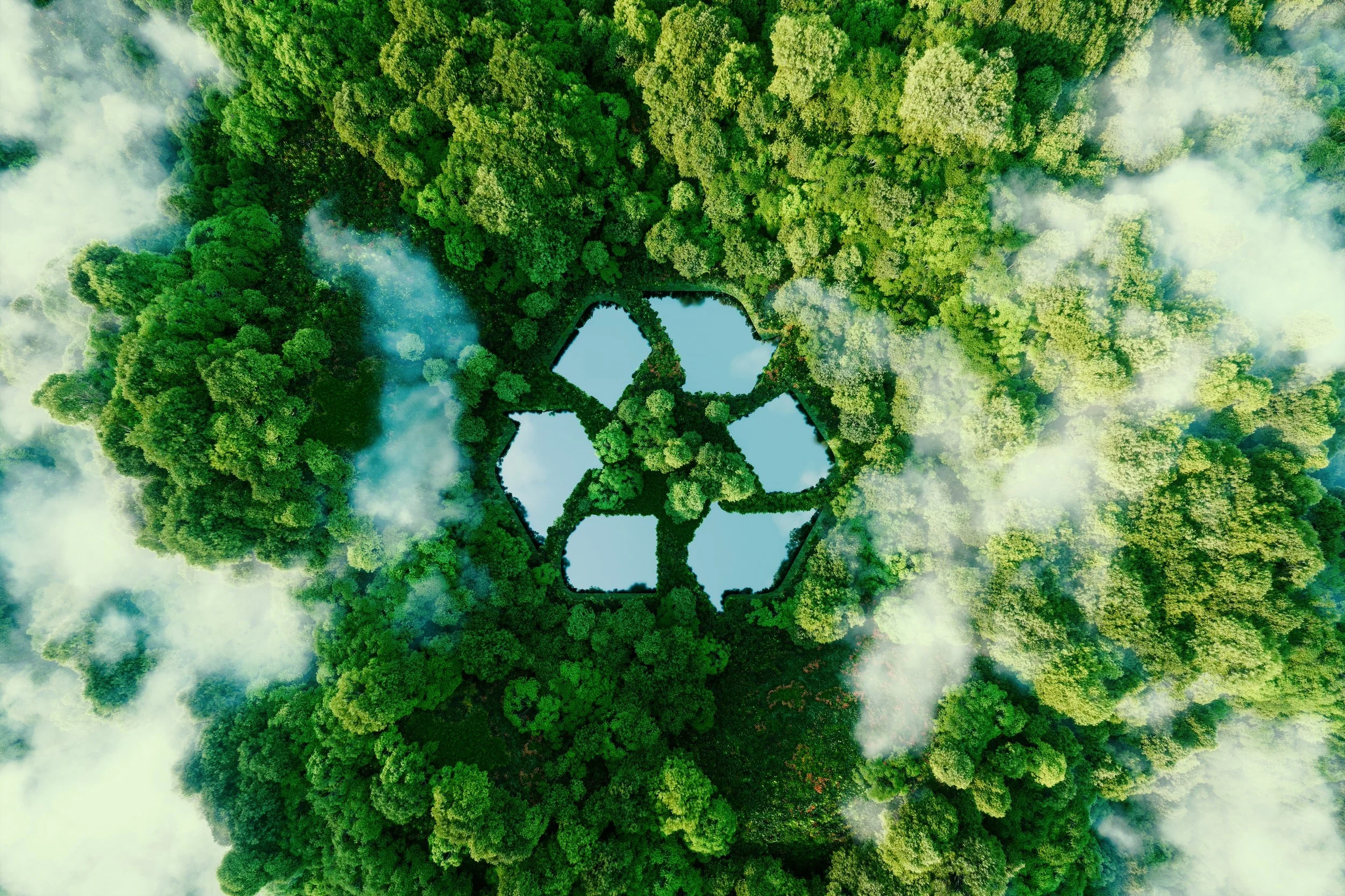 Aerial view of dense green forest with a clearing shaped like a recycling symbol filled with water reflecting the sky, surrounded by mist or clouds.