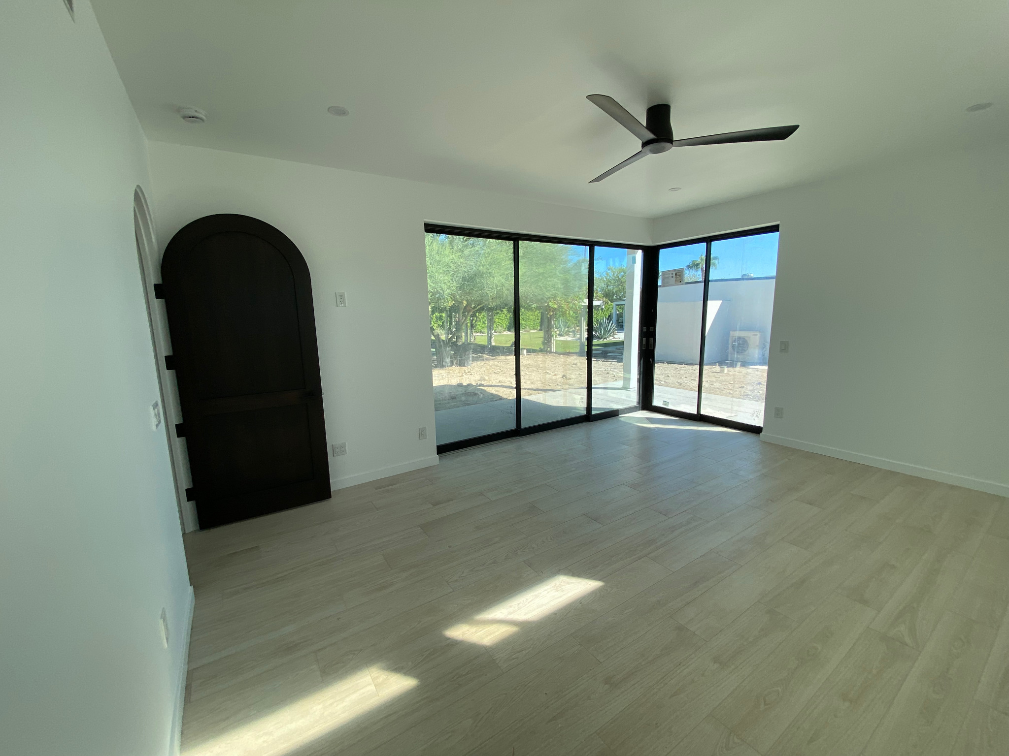 Rancho Mirage casita bedroom with black arched door and corner glazing