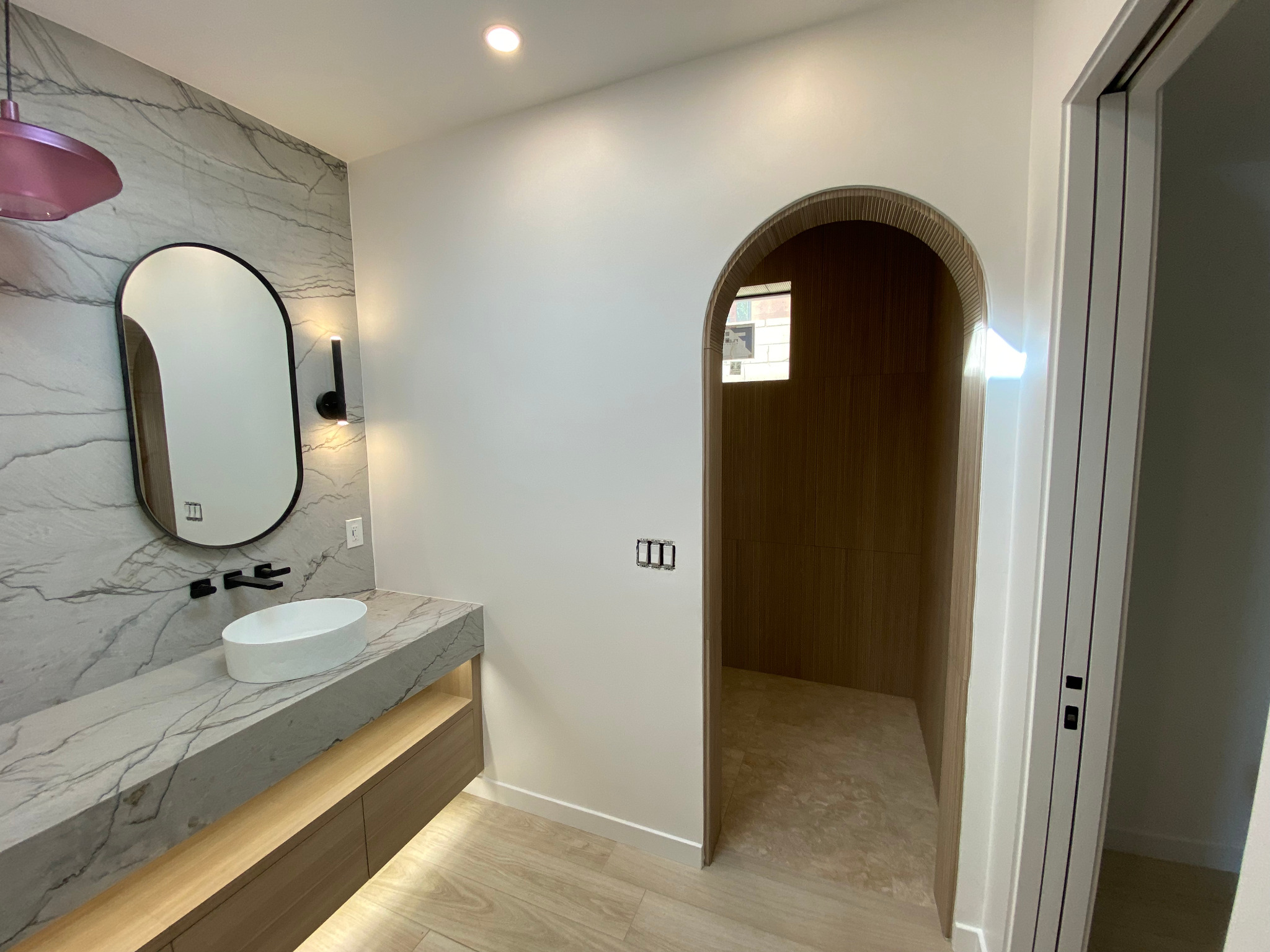 Rancho Mirage casita bathroom with stone-pattern vanity wall and arched shower opening