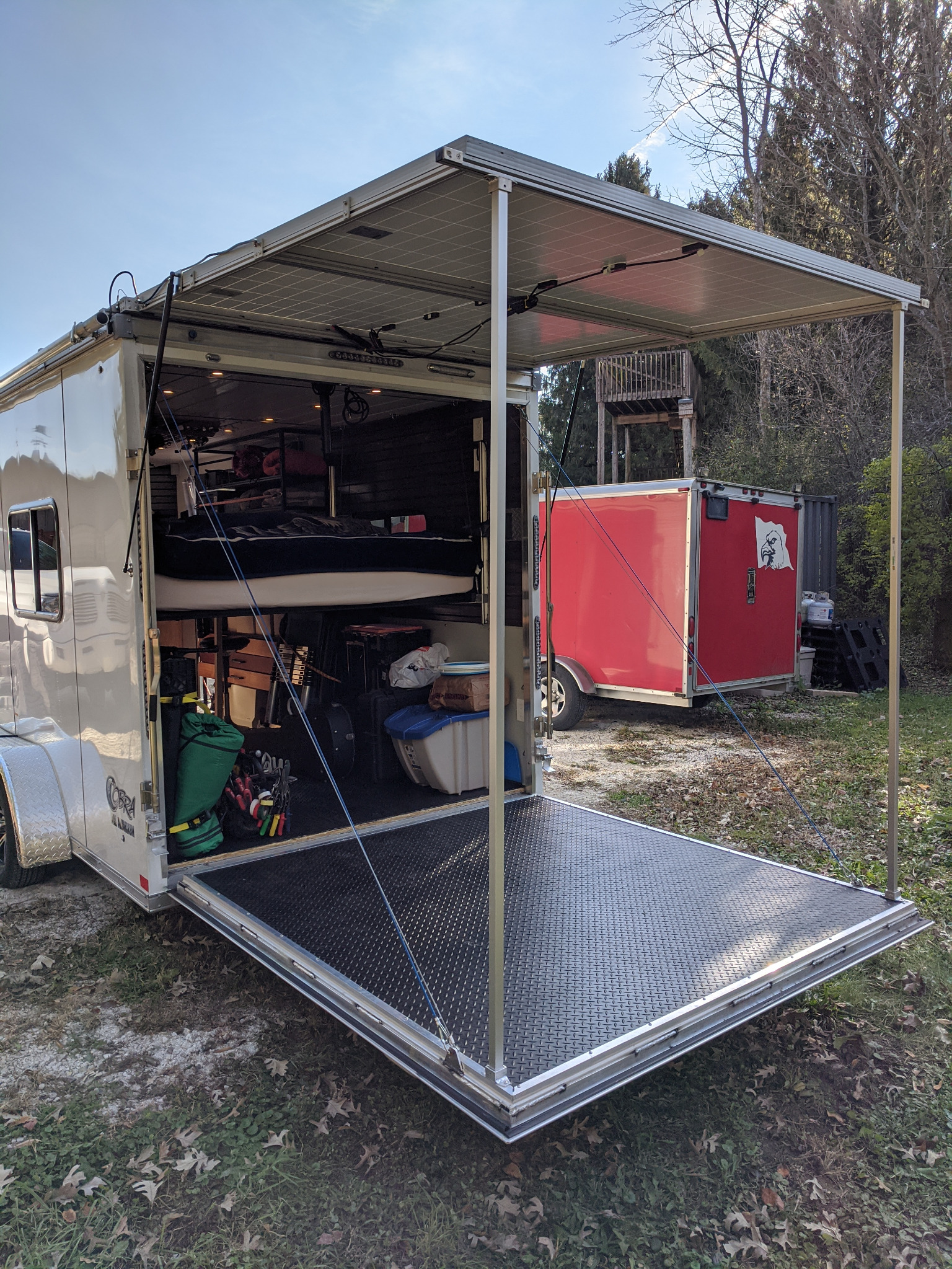 Exterior of the custom off-grid tiny home on wheels, with solar awning and rear ramp