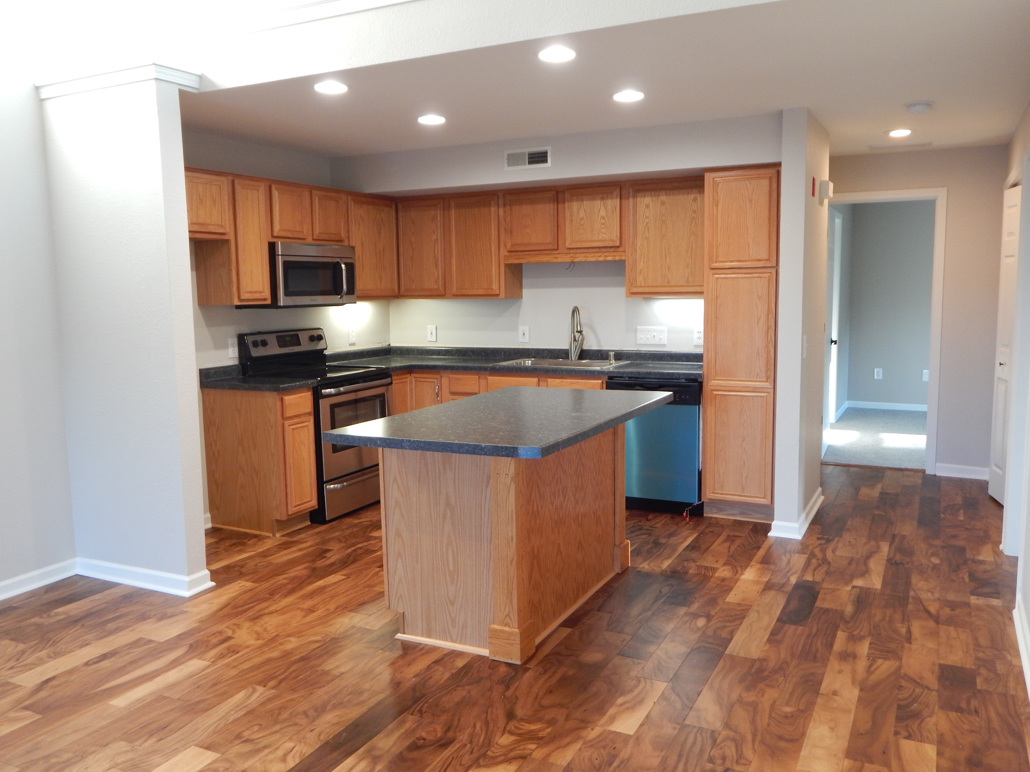 Pewaukee condominium kitchen after renovation, with wood flooring and updated finishes.
