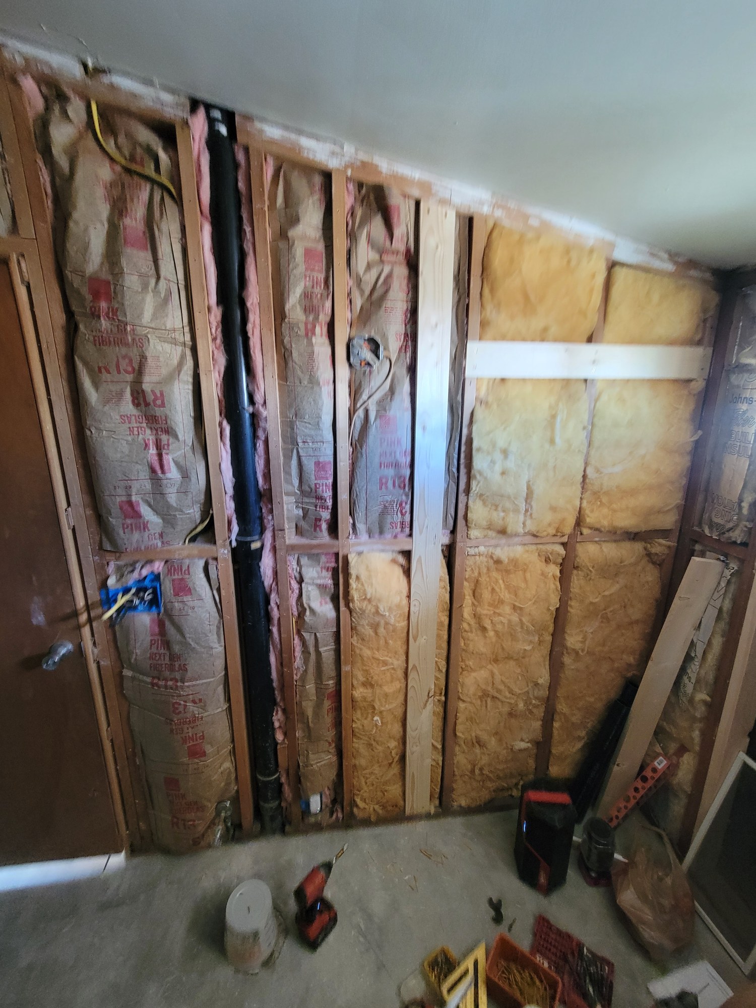 Bathroom remodel in progress with exposed framing and insulation.