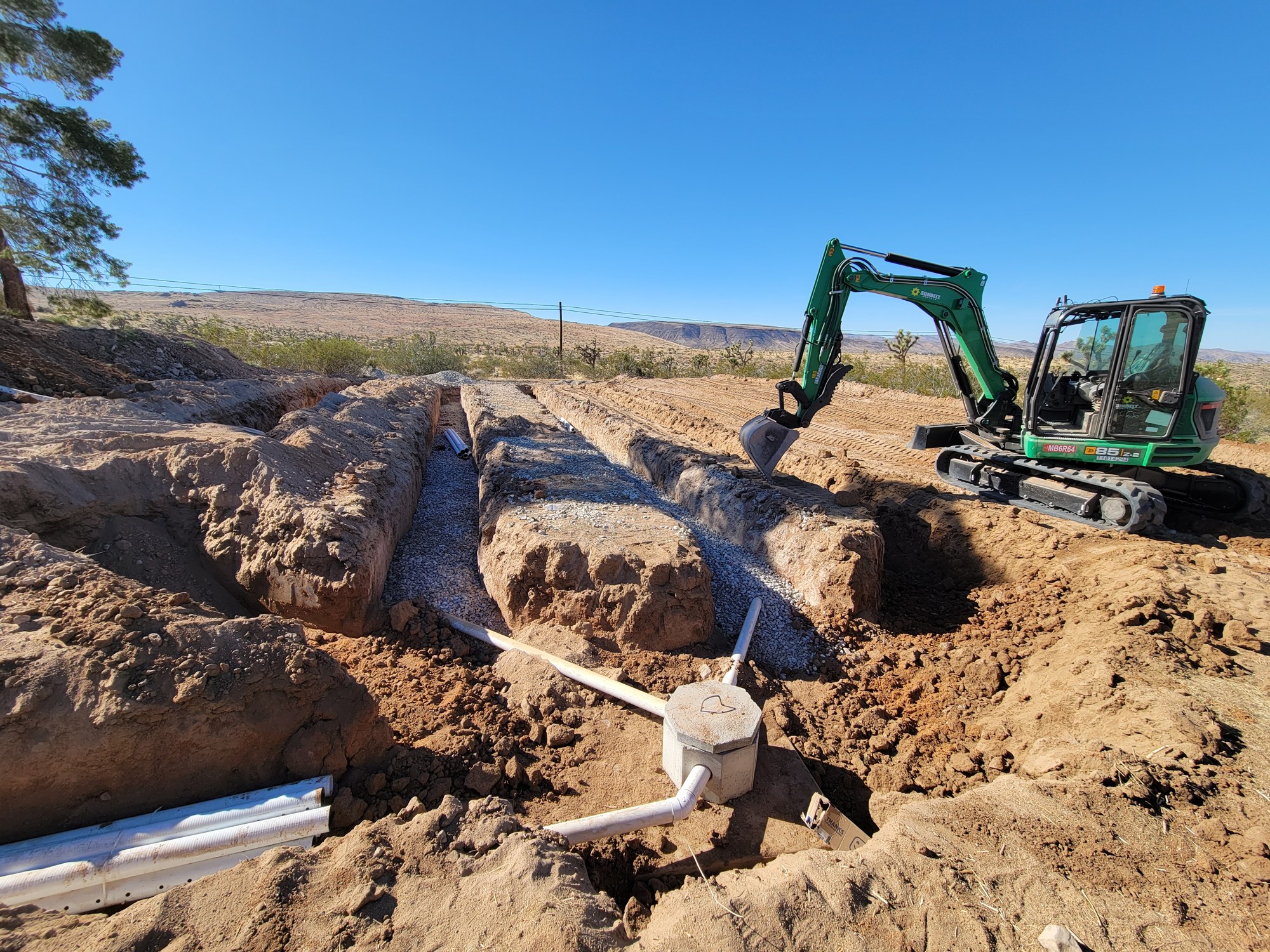 Onsite wastewater system installation stage with buried components and piping visible.
