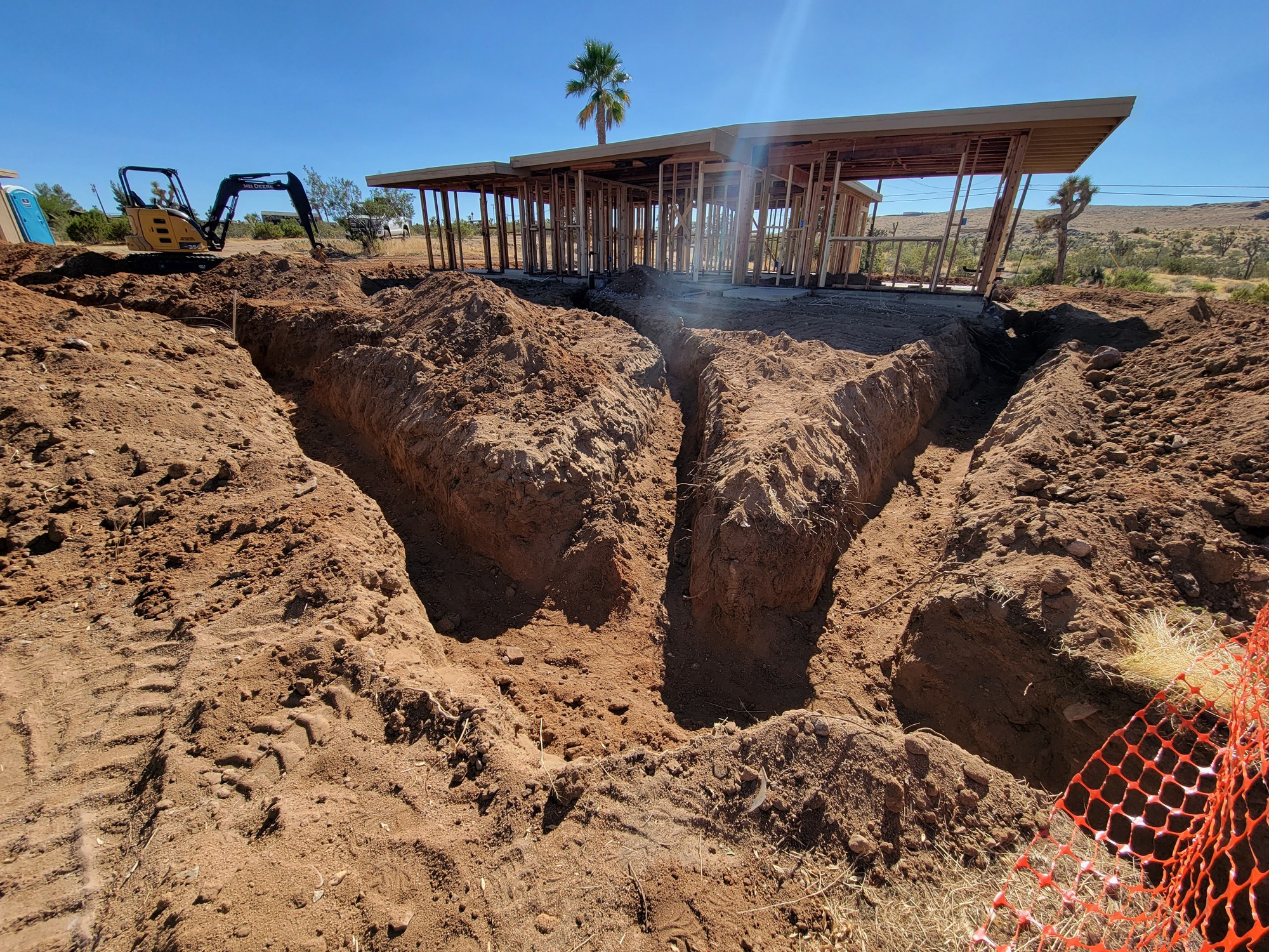 Deep connected trenches excavated for onsite wastewater system components.