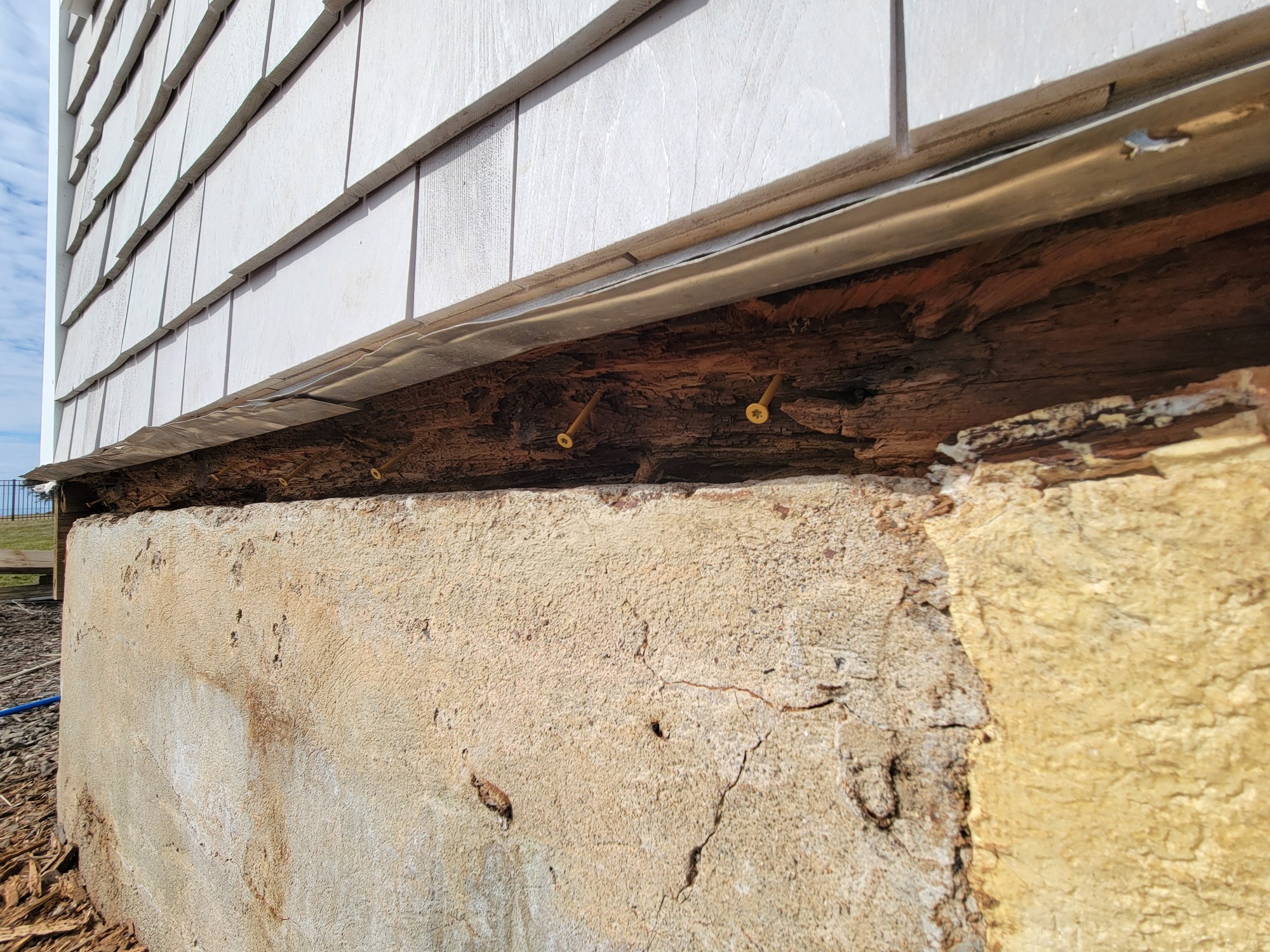 Exposed older deck framing during demolition showing deteriorated structural conditions.