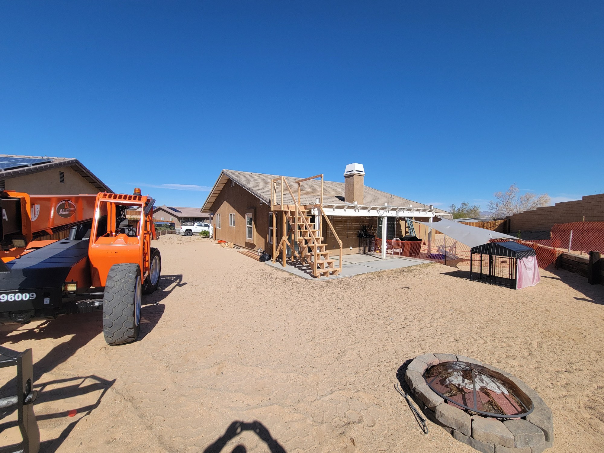 Exterior rear view of home with temporary work access and construction staging.