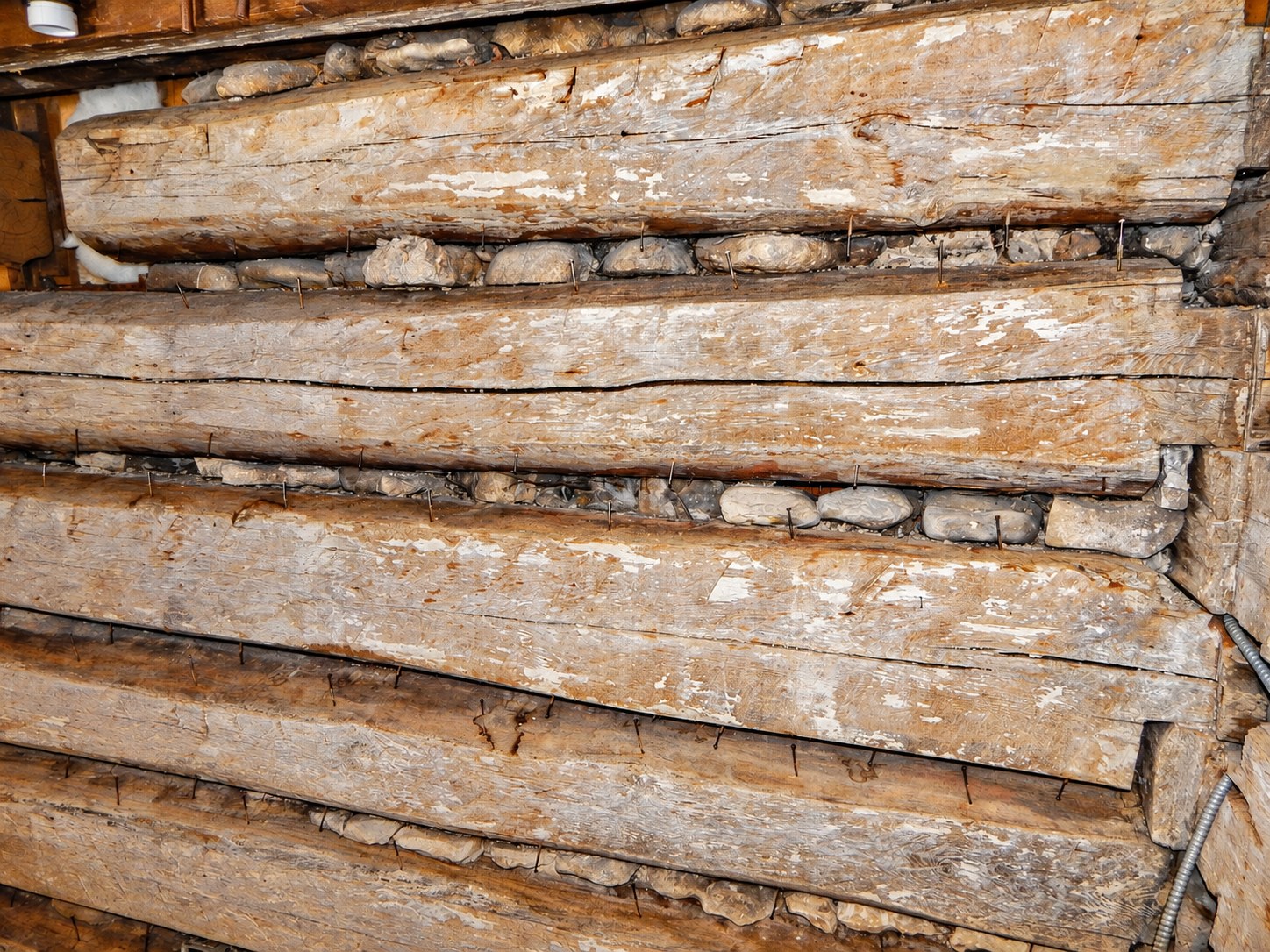 Deteriorated historic chinking and original stone packing before repair.