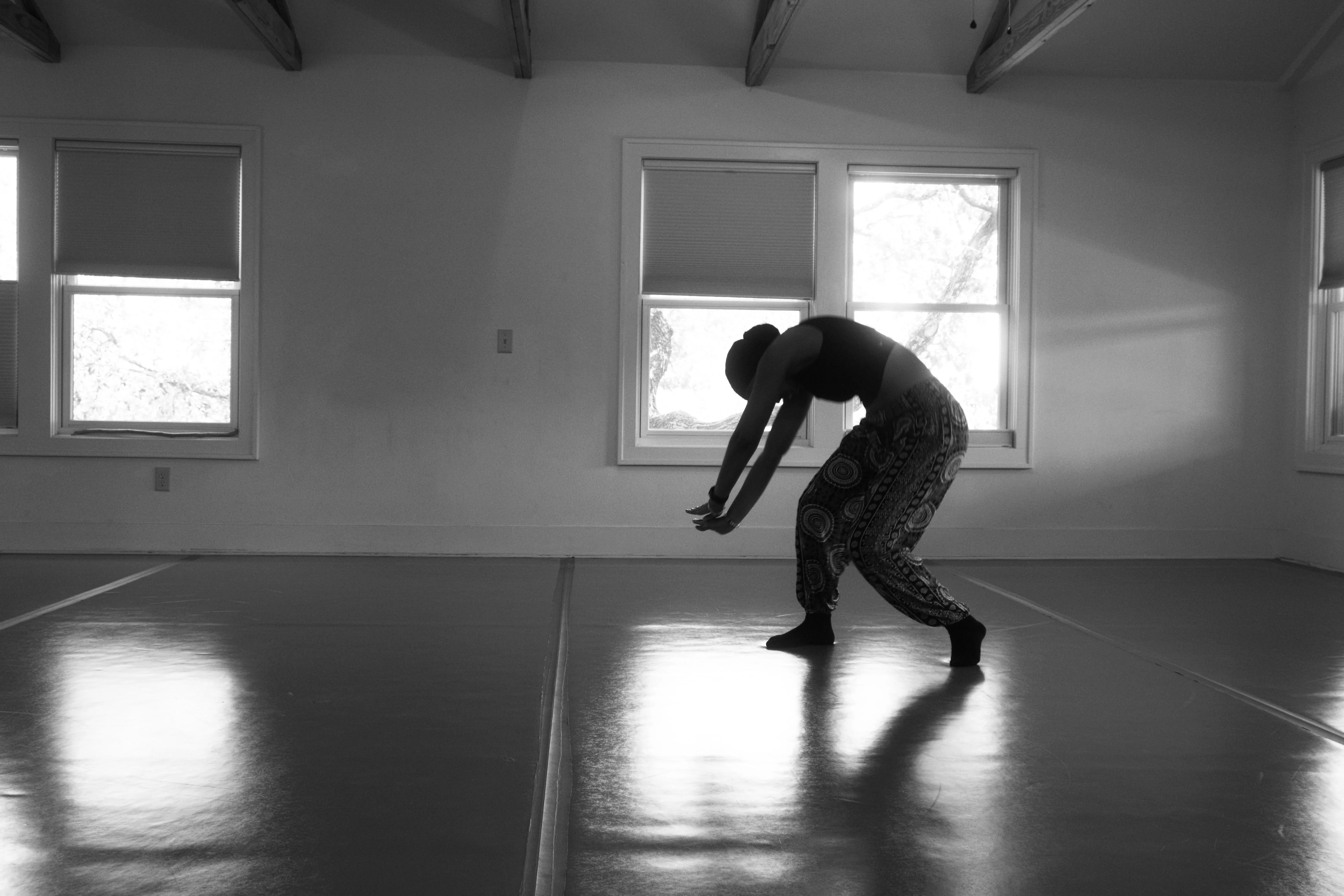 Shantal bending backward in a bright dance studio, reflected in the floor