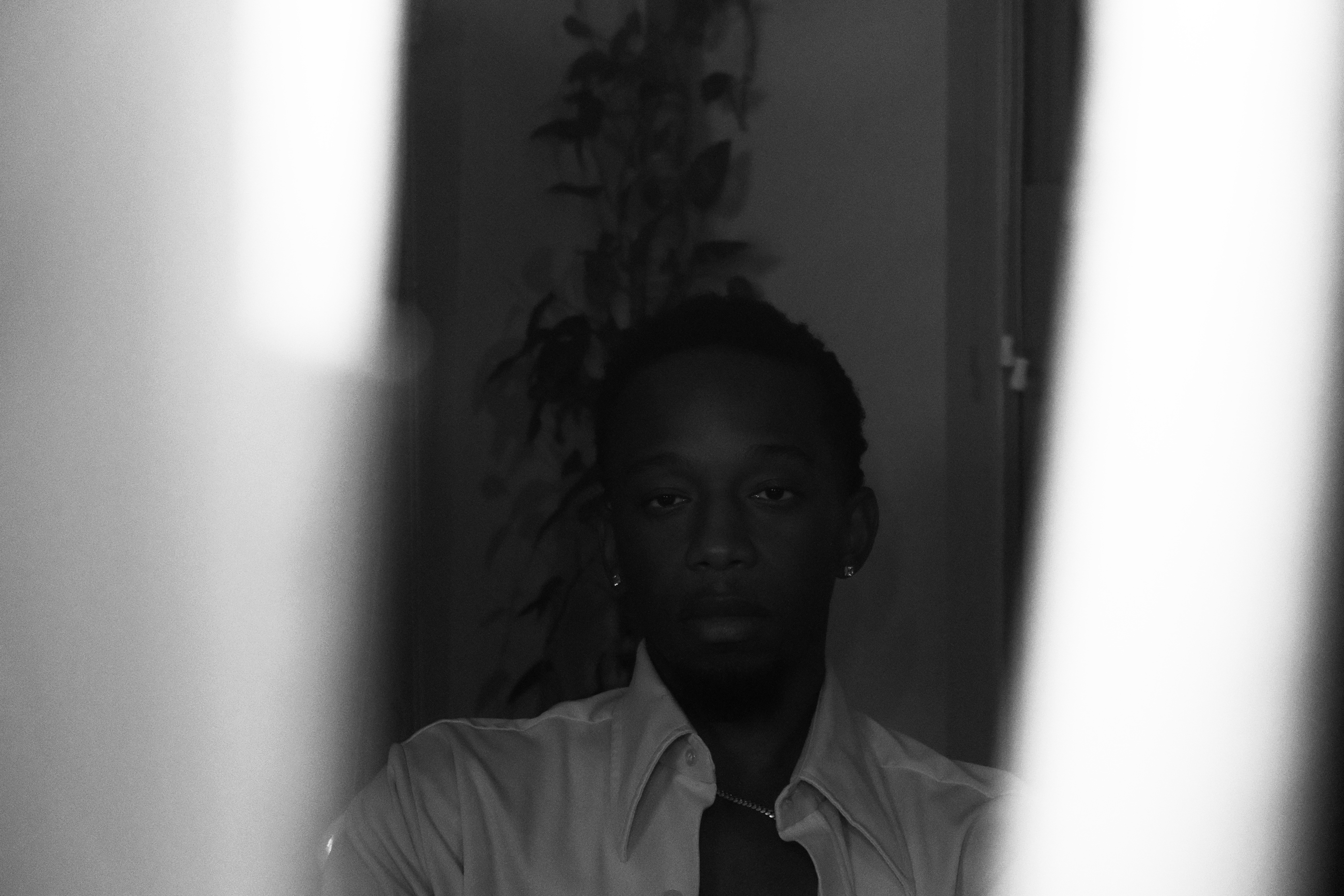 Otis looking straight into the camera in a dining room, framed between two candlesticks.