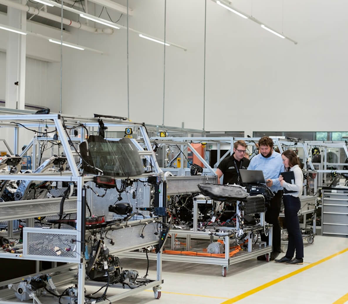Technicians reviewing readiness information on a laptop in an industrial manufacturing facility