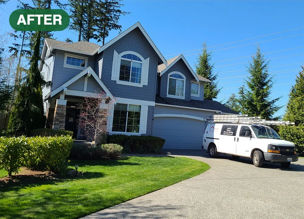 Two-story home with fresh blue-gray siding and white trim after an exterior repaint by Tino's Painting