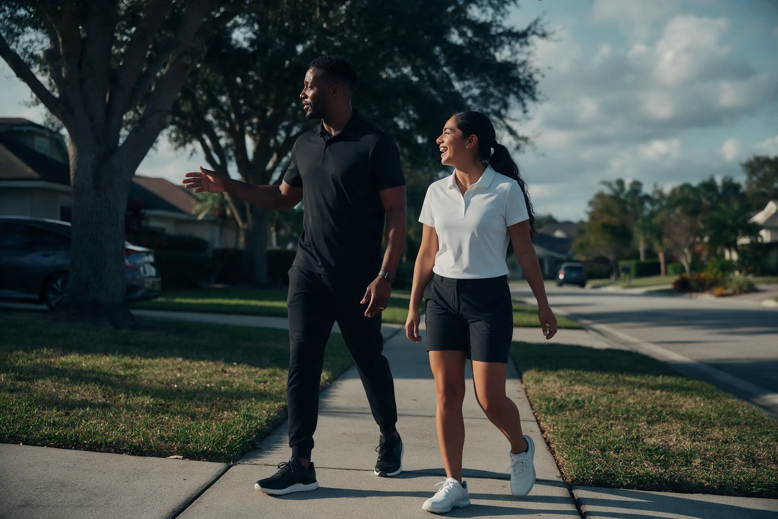 A sales leader and a new rep talk while walking a neighborhood