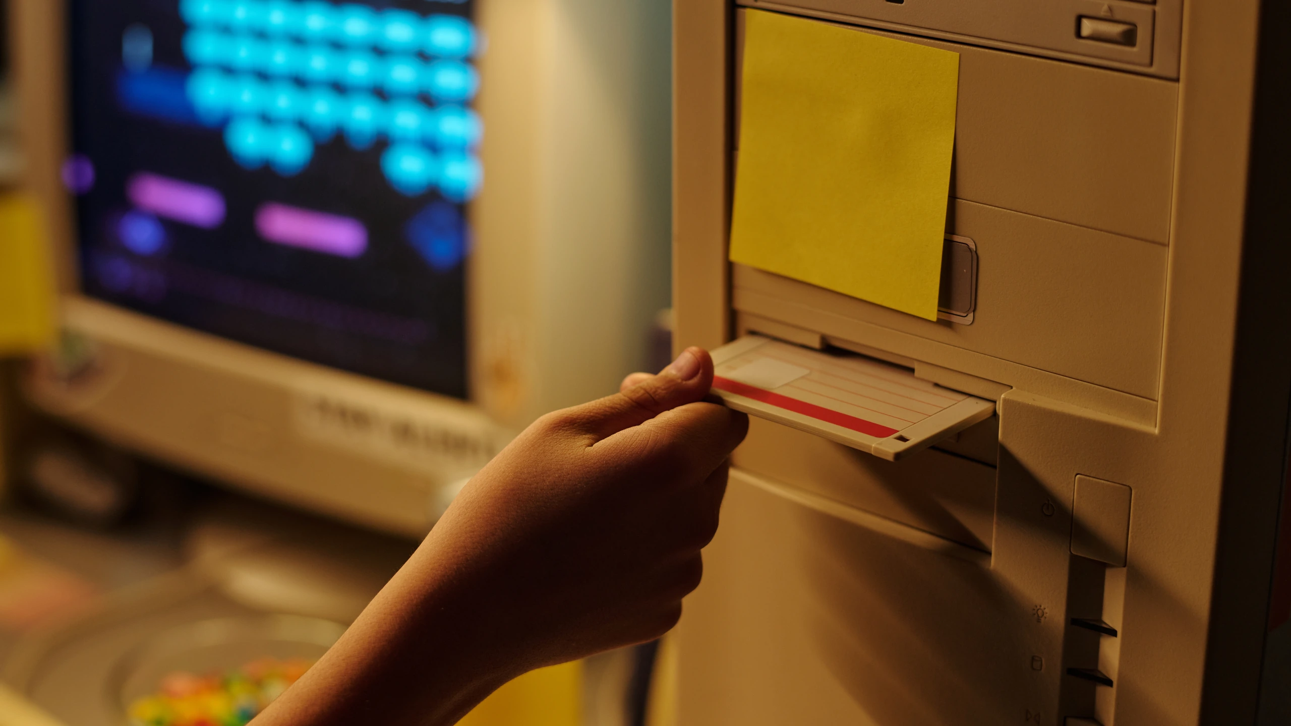 A hand using a 1990s desktop computer