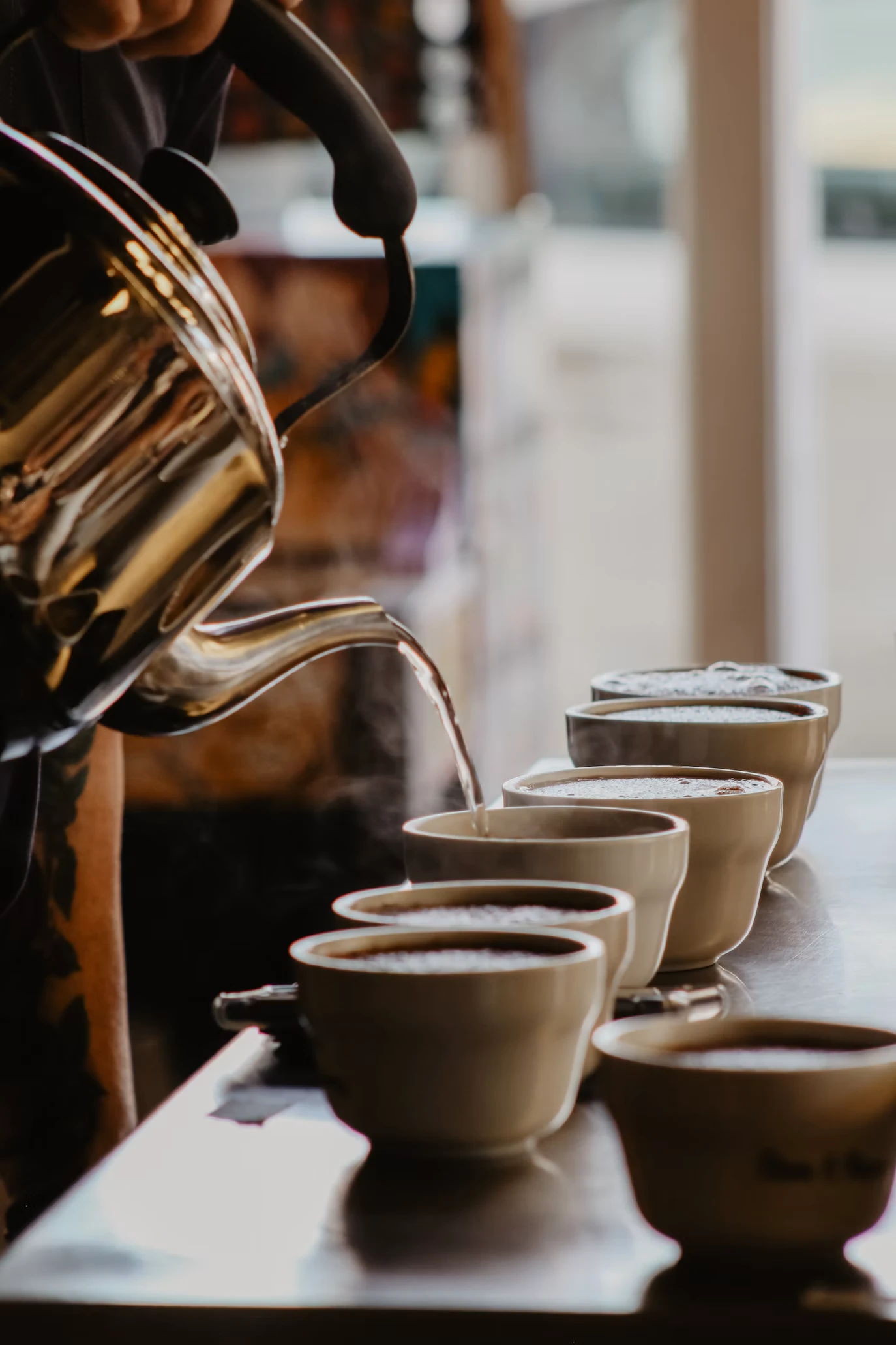 Coffee being poured into tasting cups