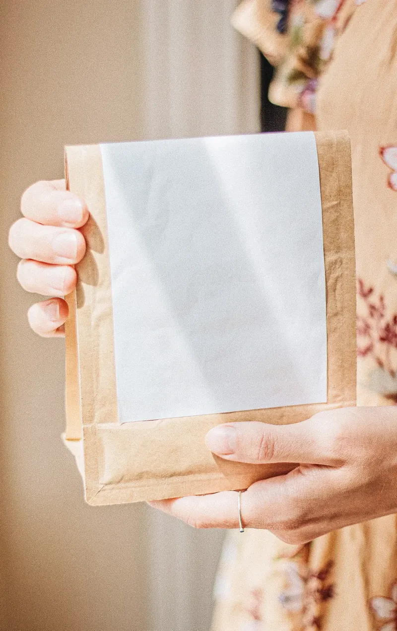 A hand holding a paper coffee bag