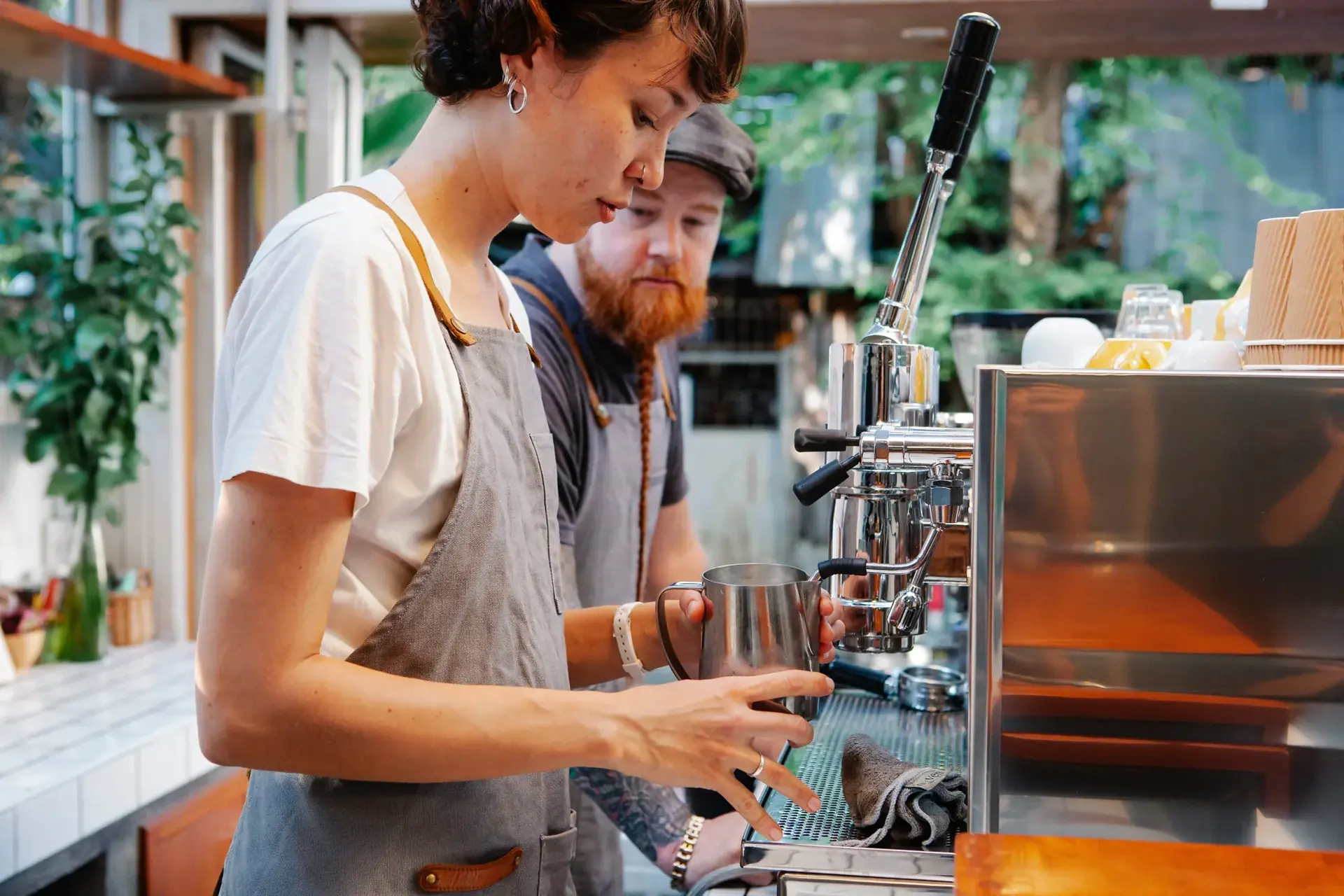 A barista preparing coffee behind the café counter