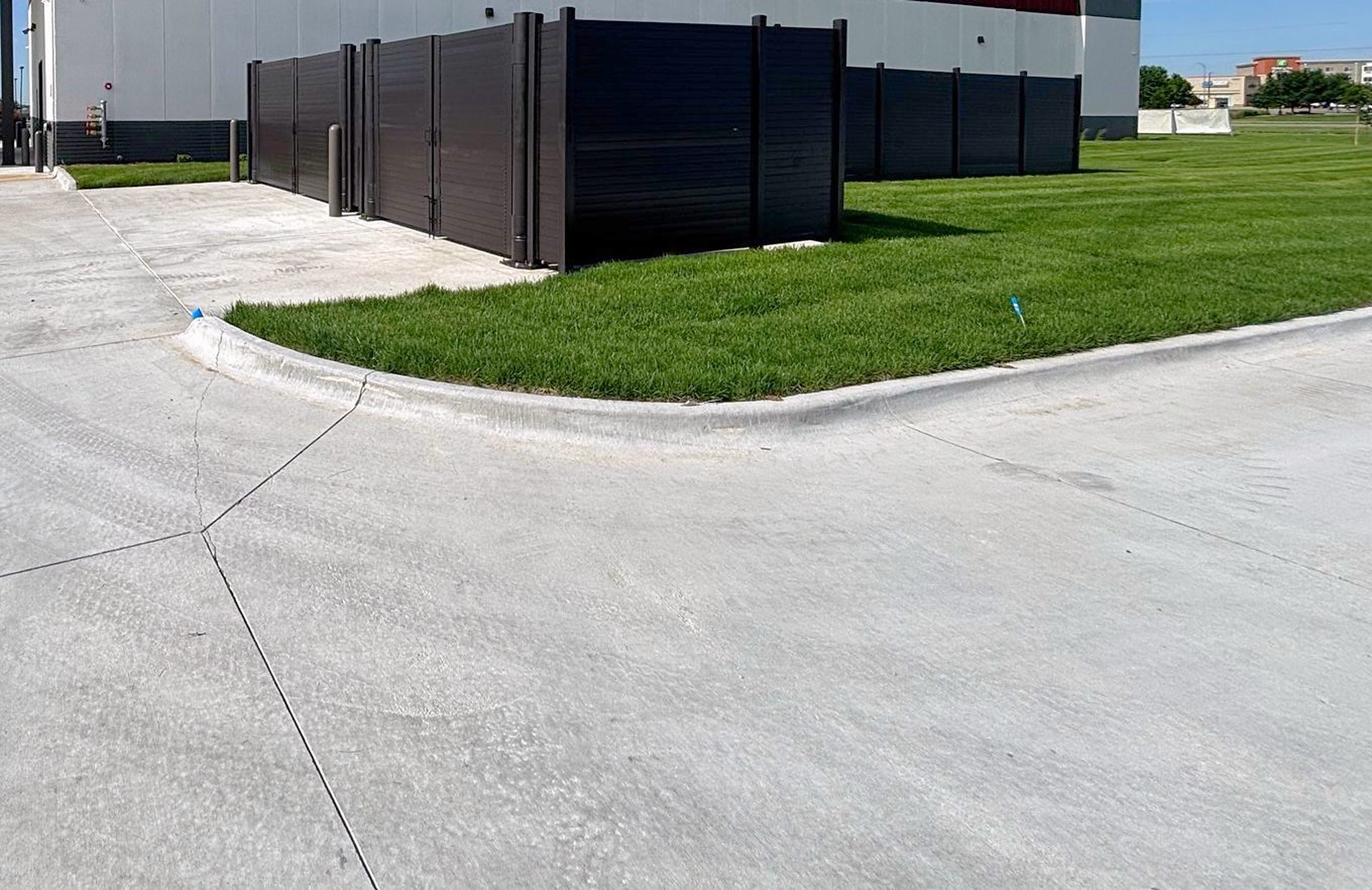 Double structural steel trash enclosure with 12 ft clear gates and bollards