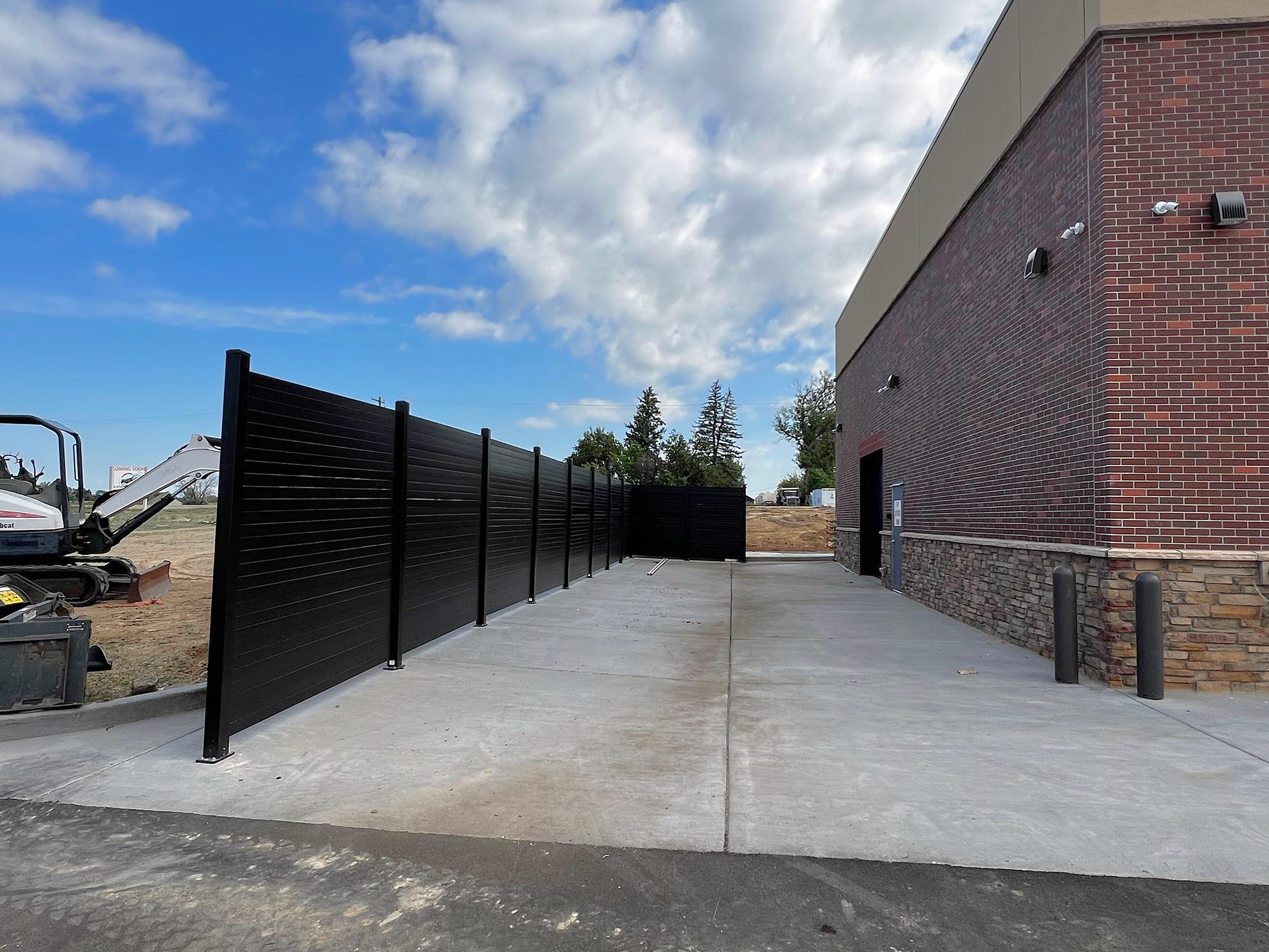 8 ft opaque steel screen wall alongside a commercial building