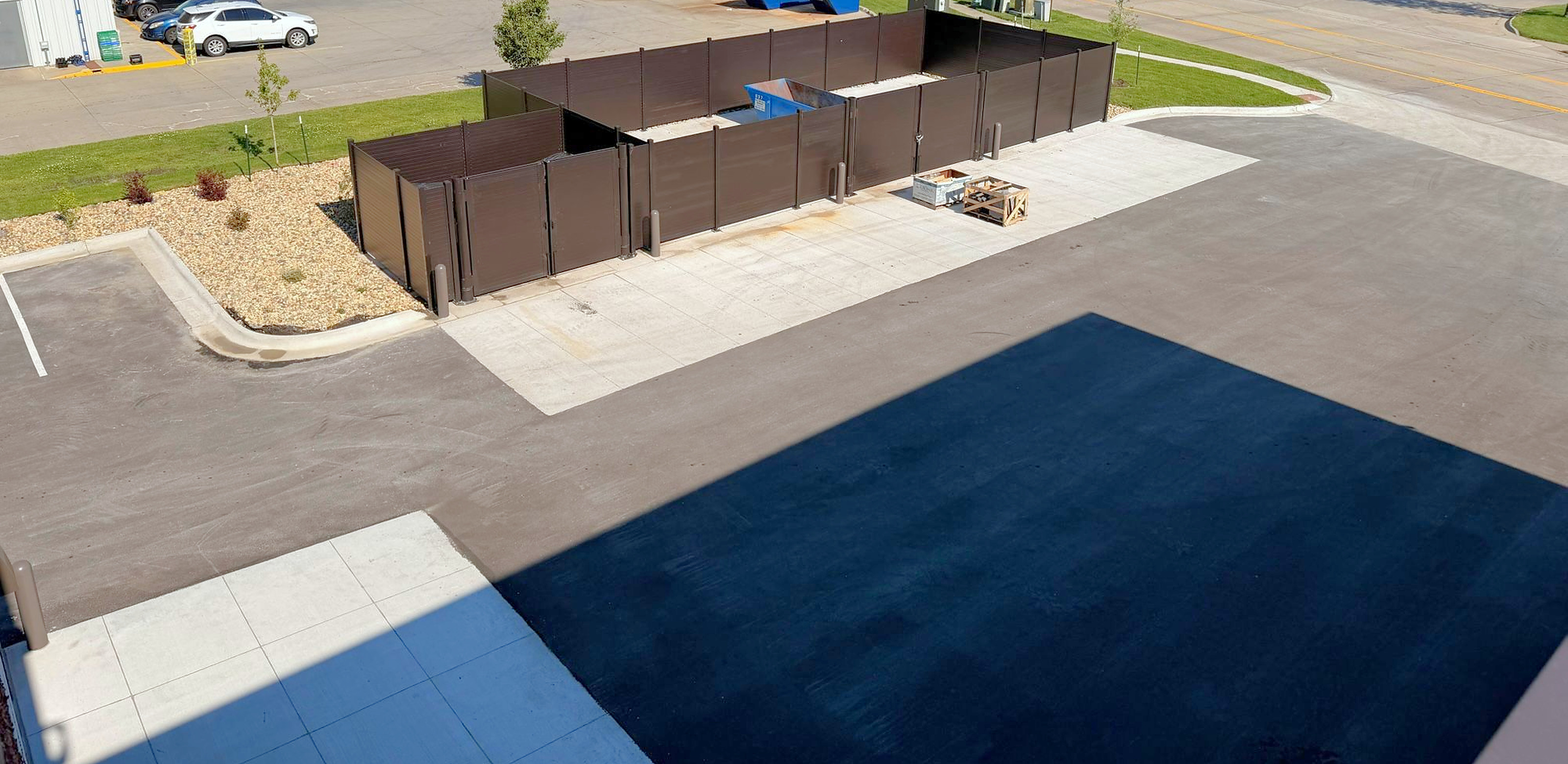 Aerial view of an L-shaped 8 ft structural steel enclosure in site context