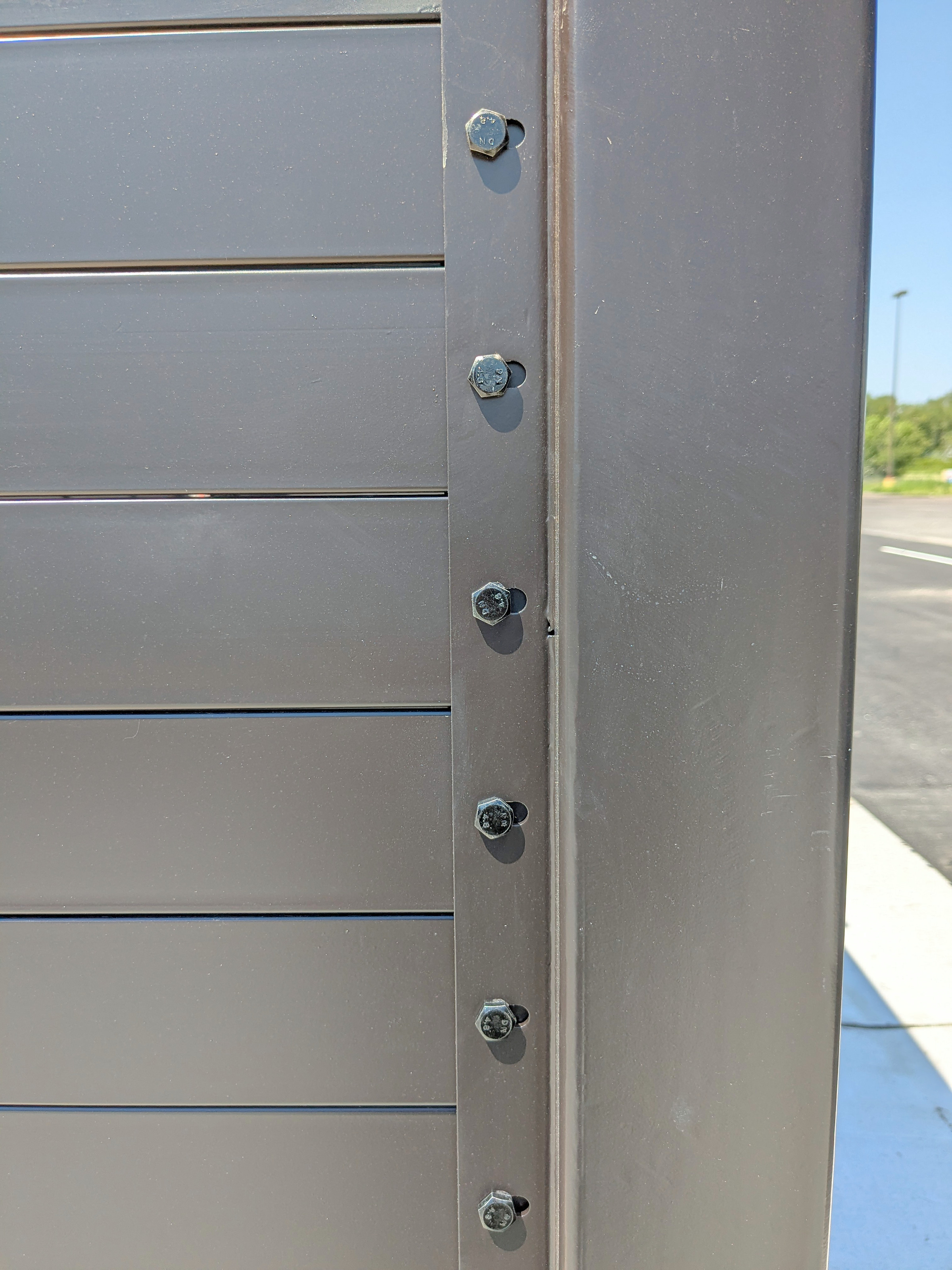 Close-up of solid steel slats bolted into a structural steel post channel